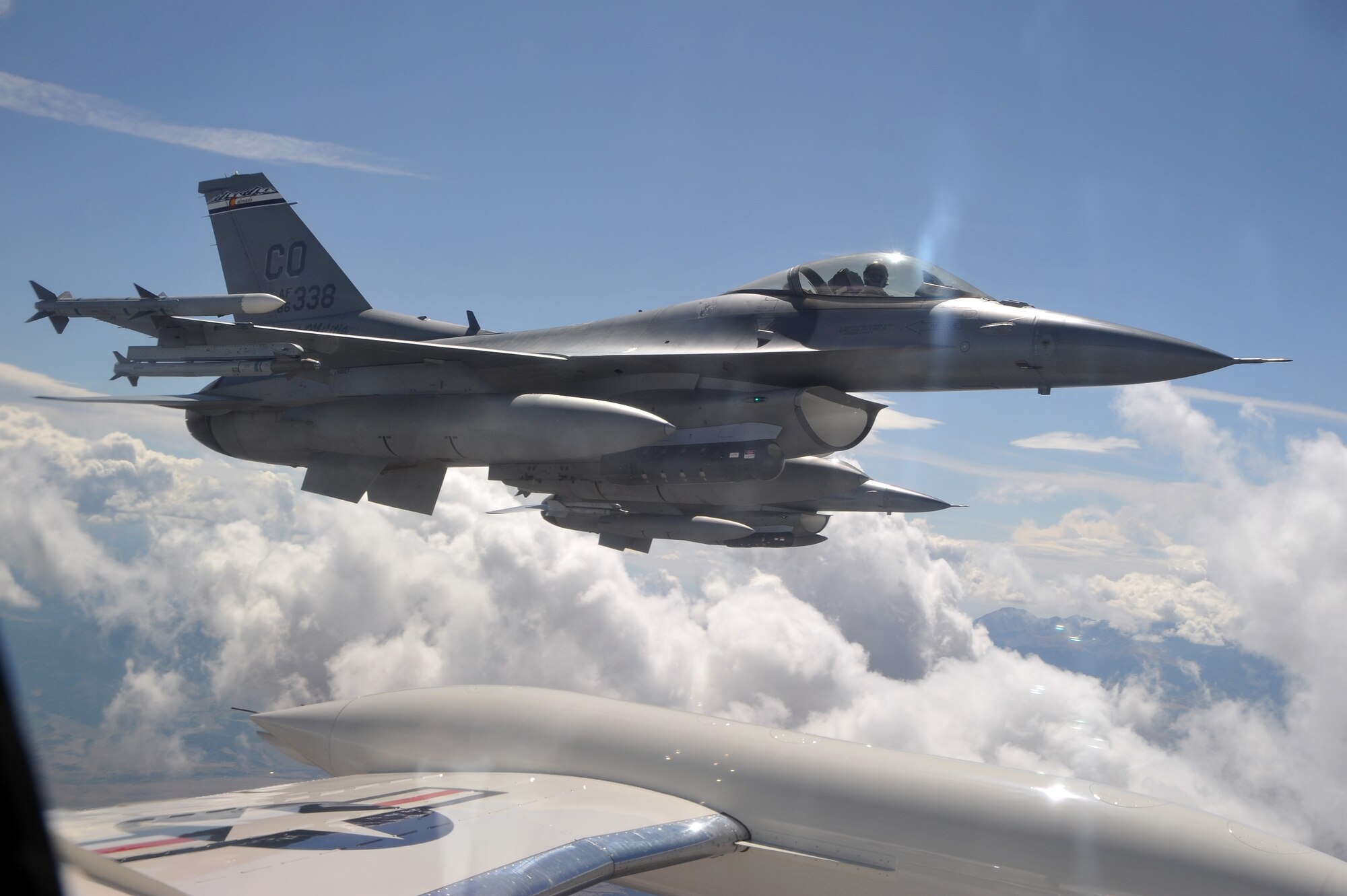 An F-16 pilot with the 120th Fighter Wing flies along the side of a C-21 Passenger Jet with the 200th Airlift Squadron both out of Buckley Air Force Base, September 20, 2009.  The Colorado Air National Guard is honoring its spouses this week in appreciation of all their support by giving them incentive flights in a C-21 over the state of Colorado. (U.S. Air Force photo by Tech. Sgt. Wolfram M. Stumpf, Colorado Air National Guard/Released) 