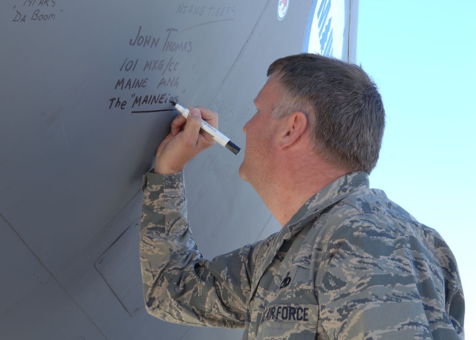 Col. John Thomas signs a KC-135 aircraft Sept. 23, after the aircraft landed on Davis-Monthan, where it will now go to retire after more than 50 years of active service. Colonel Thomas is the 101st Maintenance Group commander in the Maine Air National Guard, where the plane has spent the last two decades. (U.S. Air Force photo by Airman Jerilyn Quintanilla)