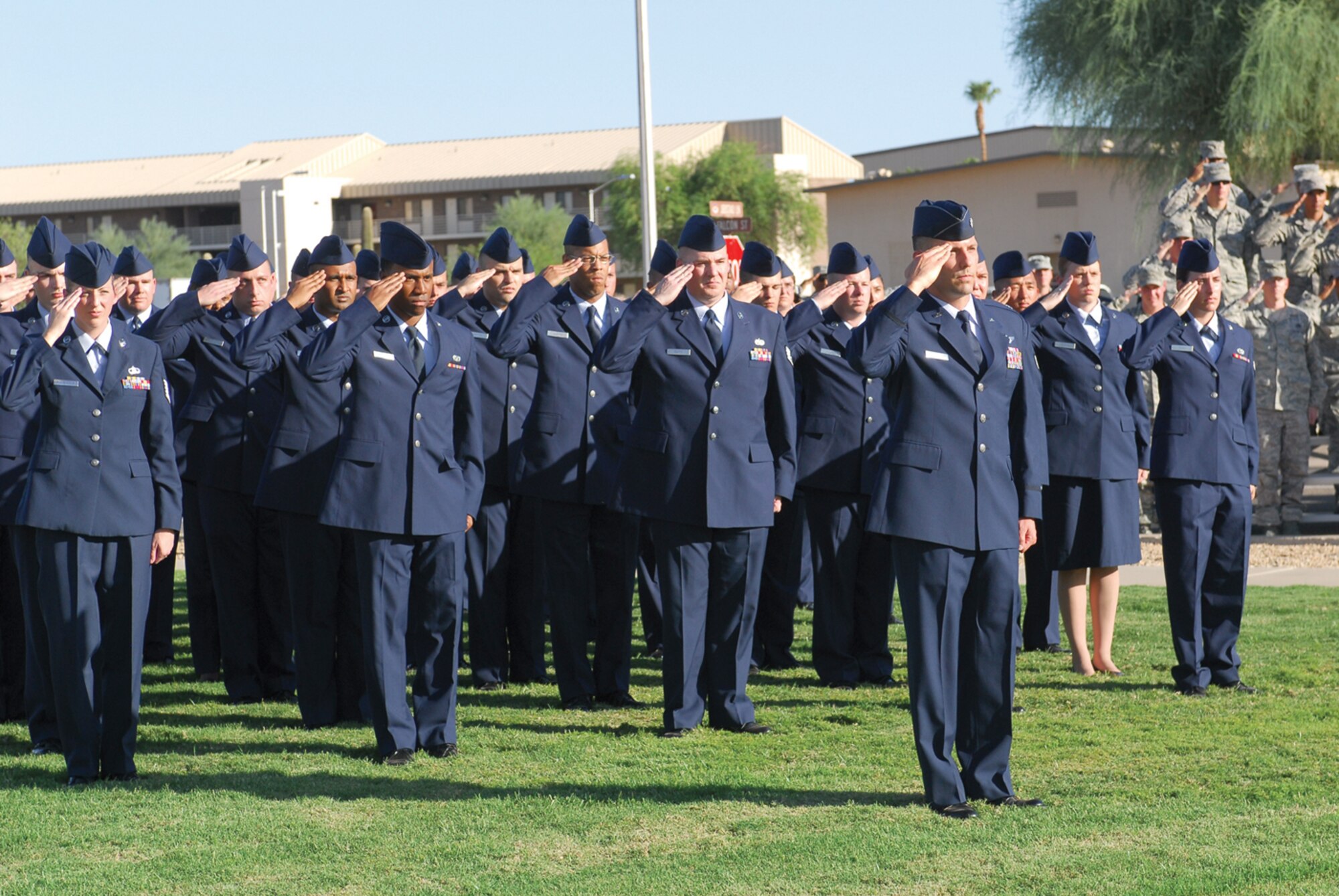 Luke Airmen salute during the singing of the National Anthem at the POW/MIA Remembrance Ceremony at the Luke Air Force Base flagpole Sept. 16. (U.S. Air Force photo/Senior Airman Tracie Forte)