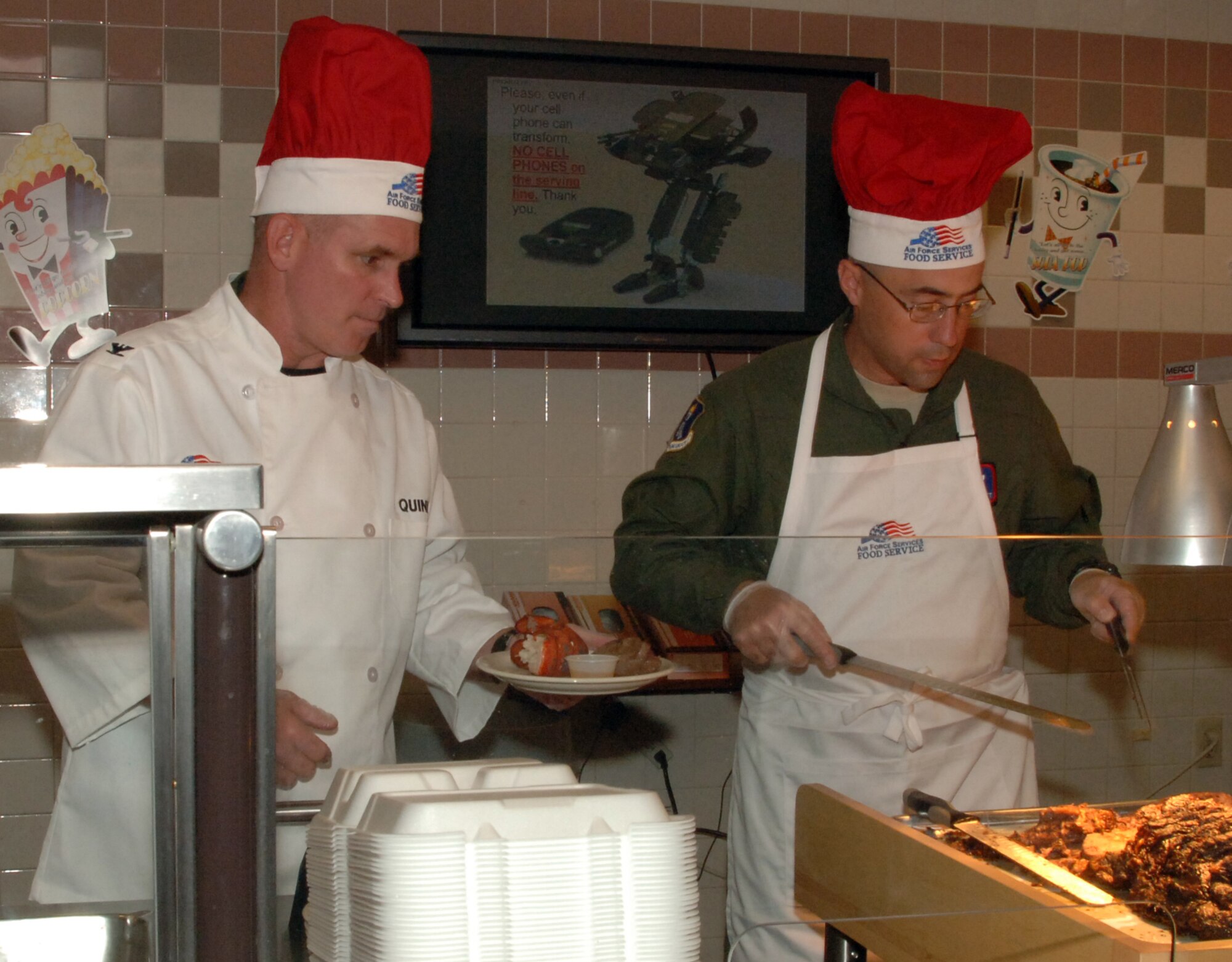 Col. John M. Quinn, 319th Air Refueling Wing vice-commander and Chief Master Sgt.  Gary L. Elliott, 905th Air Refueling Squadron superintendent, work together to plate a piece of prime rib on an Airman’s plate during the Airman Appreciation dinner at the Airey Dining Facility here, Sept. 23. The 319th ARW leadership held open the doors to the dining facility for the Airmen as well as served their dinners. The dinner was a chance for the leadership to thank the Airmen for all they do.  The menu for the dinner included lobster tail, prime rib and fried chicken. (U.S Air Force photo by Airman 1st Class Rachel R. Martinez)  