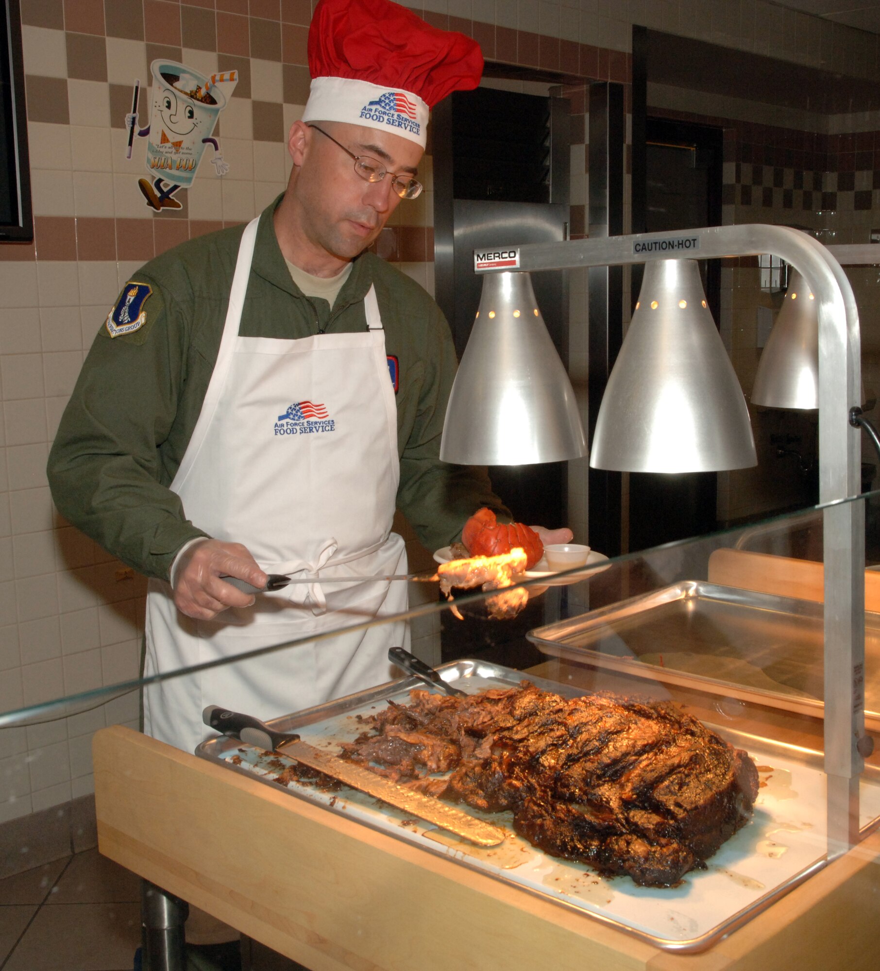 Chief Master Sgt.  Gary L. Elliott, 905th Air Refueling Squadron superintendent, places a freshly carved piece of prime rib on an Airman’s plate during the Airman Appreciation dinner at the Airey Dining Facility here, Sept. 23. The 319th Air Refueling Wing’s leadership held open the doors to the dining facility for the Airmen as well as served their dinners. The dinner was a chance for the leadership to thank the Airmen for all they do.  The menu for the dinner included lobster tail, prime rib and fried chicken. (U.S Air Force photo by Airman 1st Class Rachel R. Martinez)  
