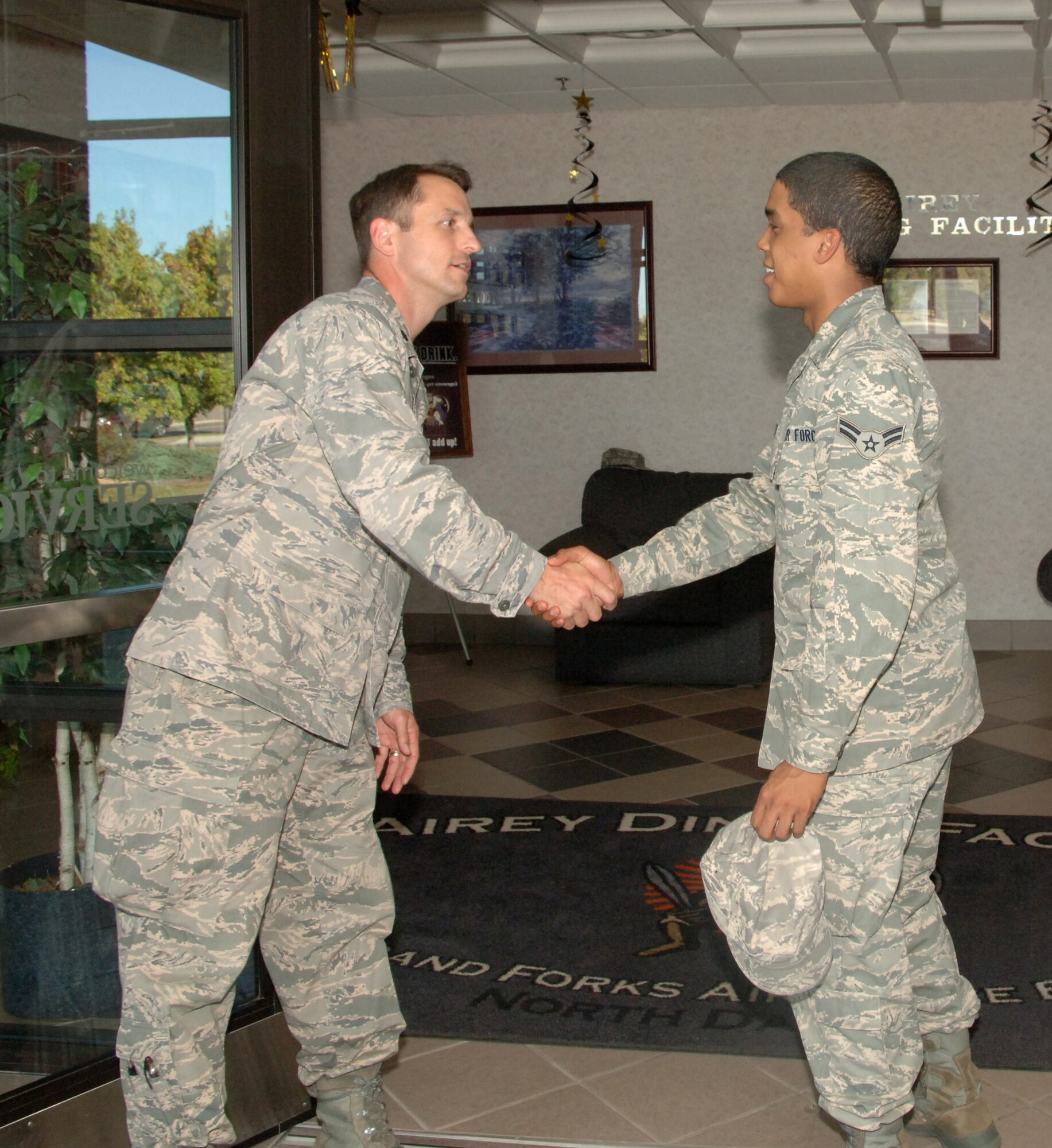 Lt. Col. Kevin J. Yandura, 319th Air Refueling Wing Director of Staff, shakes Airman 1st Class Jon-Nicos Walker’s, 319th Comptroller Squadron, hand as Airman Walker walks into the Airey Dining Facility here, to enjoy the Airman Appreciation dinner Sept. 23. The 319th ARW leadership held open the doors to the dining facility for the Airmen as well as served their dinners. The dinner was a chance for the leadership to thank the Airmen for all they do.  The menu for the dinner included lobster tail, prime rib and fried chicken. (U.S Air Force photo by Airman 1st Class Rachel R. Martinez)  