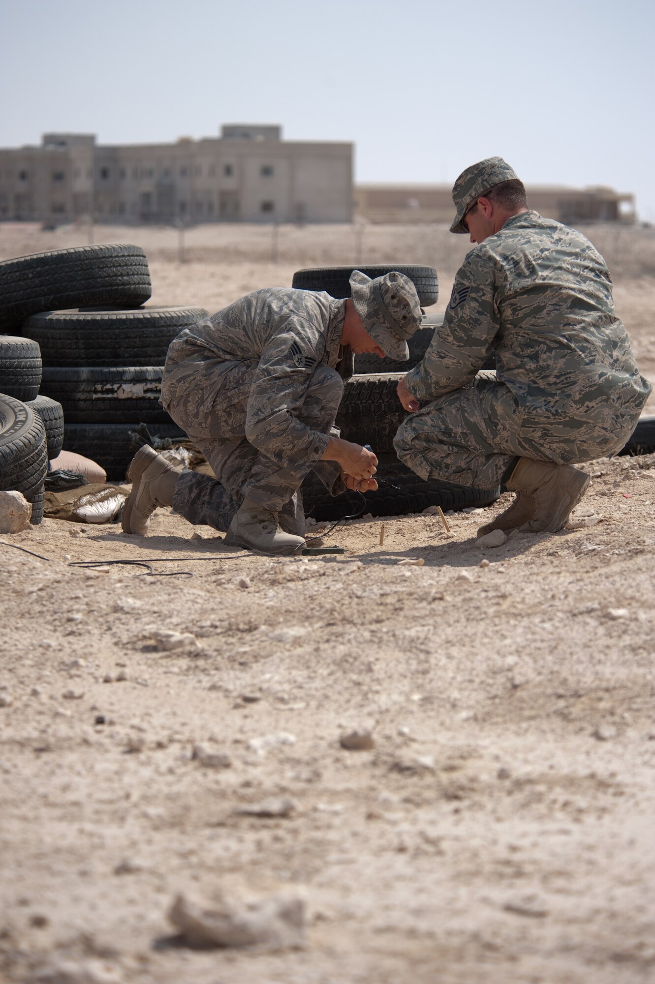 Left, Senior Airman Michael Ault and Staff Sgt. Michael Perkins, 379th Expeditionary Civil Engineer Squadron explosive ordnance disposal members, conduct monthly proficiency training, Sept. 18, in Southwest Asia. The 379 EOD team trains on a variety of simulated situations continually to ensure mission readiness. Airman Ault is deployed from Charleston Air Force Base, S.C., and Sergeant Perkins is deployed from Nellis AFB, Nev. Both are deployed in support of Operations Iraqi and Enduring Freedom. (U.S. Air Force photo/Staff Sgt. Robert Barney) 