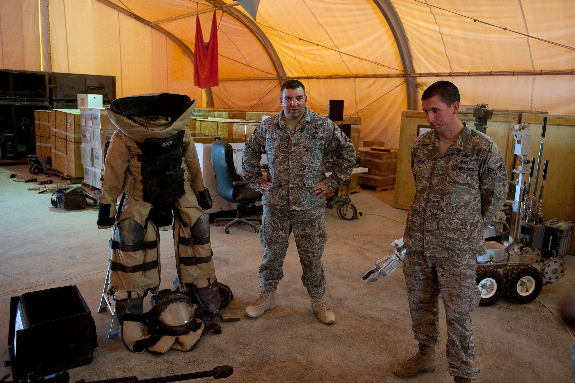 Left, Master Sgt. Martin Coleman and Senior Airman Jonathon Winter, 379th Expeditionary Civil Engineer Squadron explosive ordnance disposal members, explain their working tools for visitors, Sept. 18, in Southwest Asia. The 379 EOD team uses a variety of tools to support local aircraft and anti-terrorism force protection in support of Operations Iraqi and Enduring Freedom. (U.S. Air Force photo/Staff Sgt. Robert Barney) 