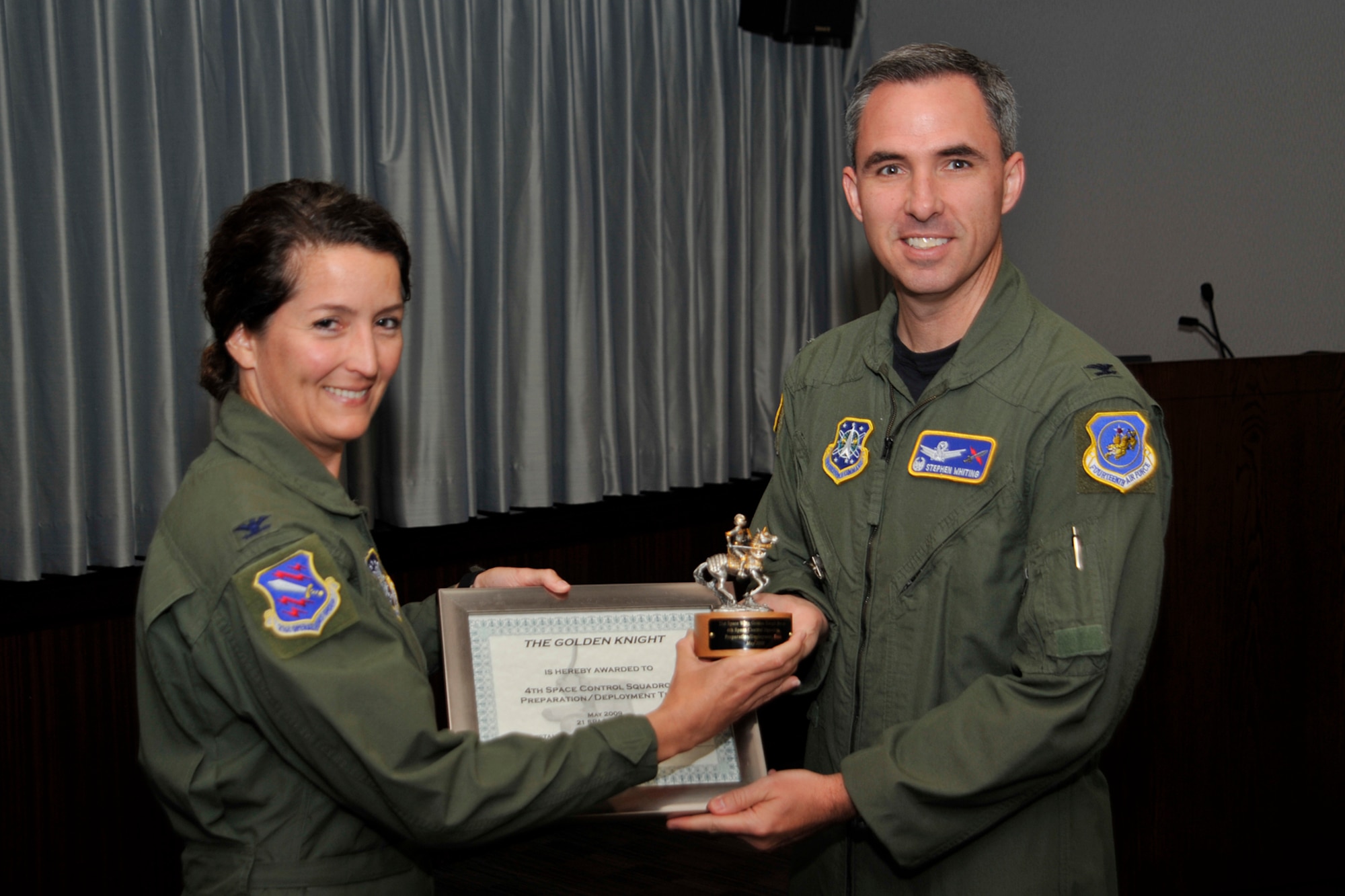 Col. Stephen Whiting, 21st Space Wing commander, presented the Golden Knight Award for May to the 4th Space Control Squadron preparation/deployment team, for deploying critical assets to the AOR. Col. Nina Armagno, 21st Operations Group commander, accepted the award on behalf of the squadron. The 4th SPCS, located at Holloman Air Force Base, N.M., provides combat space superiority effects to the commander of Joint Functional Component Command - Space (JFCC - Space) and theater combatant commanders. The squadron is one of the 21st Space Wing’s geographically separated units. (Air Force photo by Robb Lingley)