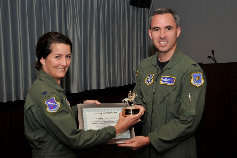 Col. Stephen Whiting, 21st Space Wing commander, presented the Golden Knight Award for May to the 4th Space Control Squadron preparation/deployment team, for deploying critical assets to the AOR. Col. Nina Armagno, 21st Operations Group commander, accepted the award on behalf of the squadron. The 4th SPCS, located at Holloman Air Force Base, N.M., provides combat space superiority effects to the commander of Joint Functional Component Command - Space (JFCC - Space) and theater combatant commanders. The squadron is one of the 21st Space Wing’s geographically separated units. (Air Force photo by Robb Lingley)