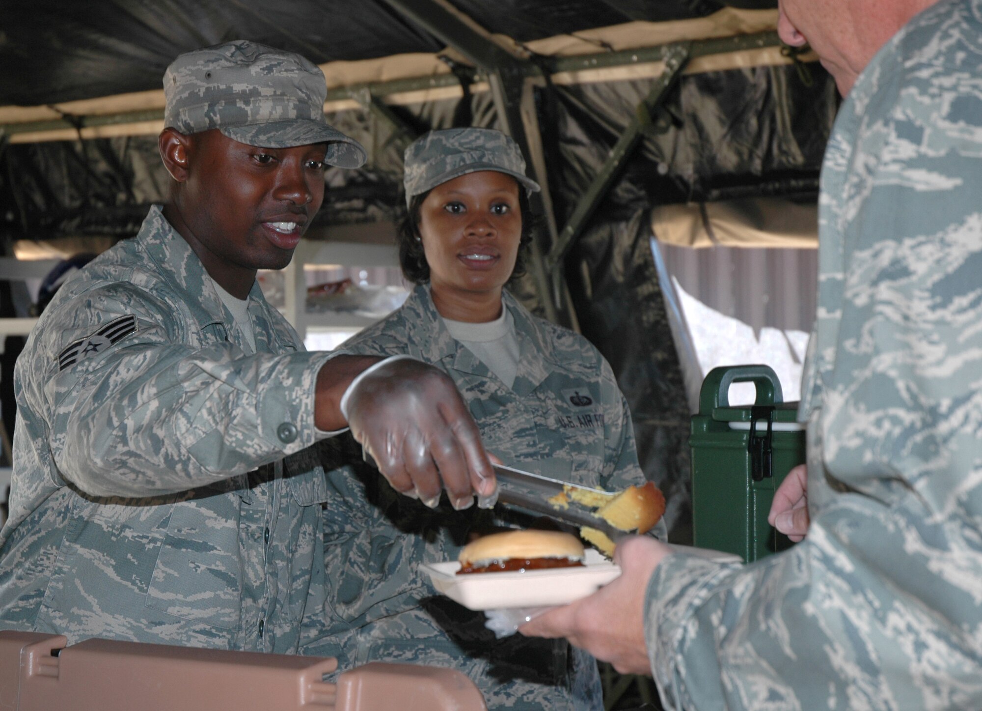 Senior Airman Ronald McKinney and Staff Sgt. Hope Clark-Vasquez, 302nd Services Flight, take care of hungry Airmen Sept. 19 during single palletized expeditionary kitchen training at Peterson Air Force Base, Colo. The services flight trains with the SPEK kitchen unit every three months. (U.S. Air Force photo/Tech. Sgt. Daniel Butterfield)