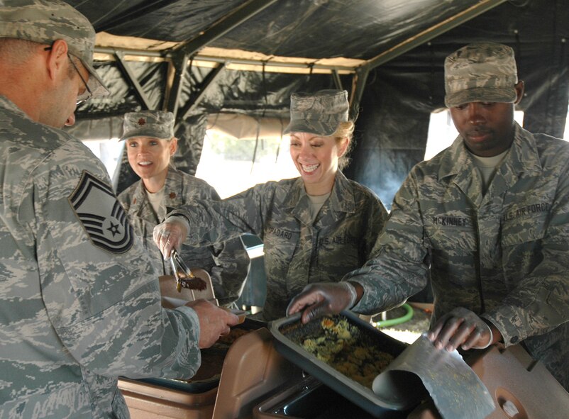 Master Sgt. Angelique Spadaro, 302nd Services Flight first sergeant, serves up a helping of ribs to a 302nd Airlift Wing Airmen Sept. 19 at Peterson Air Force Base, Colo. Sergeant Spadaro and Airmen of the 302nd SVF train on the single palletized expeditionary kitchen, or 'SPEK,' unit every three months. (U.S. Air Force photo/Tech. Sgt. Daniel Butterfield)