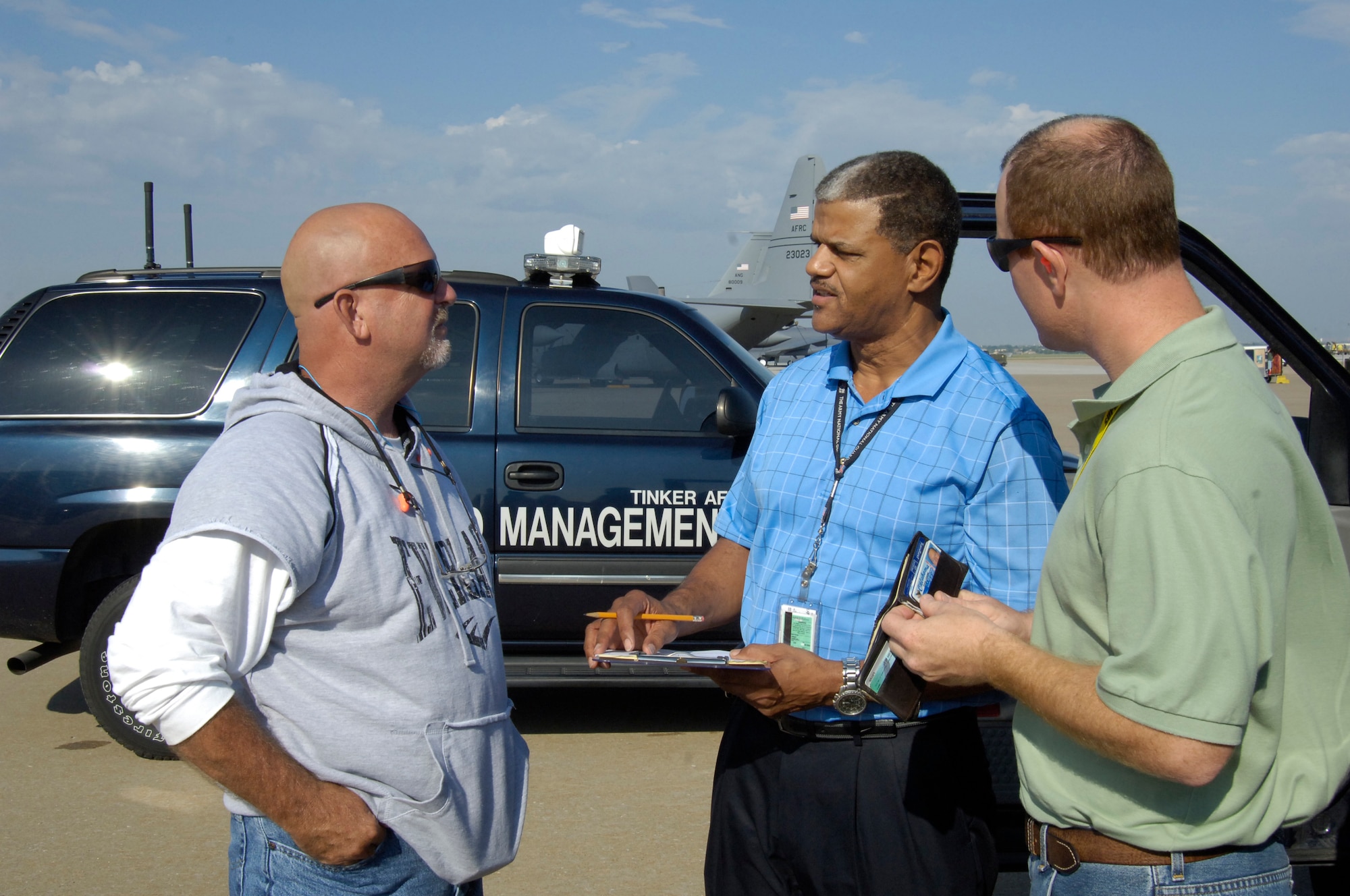 Assistant airfield manager, Charles Grant, center, conducts a random check for airfield drivers licenses to make sure that everyone on the airfield is trained and qualified. Mr. Grant validates everyone from Security Force to contractors. Left is Greg Ott and right is Erik Dahlgren, both KC-135 post dock members. (Air Force photo by Margo Wright)
