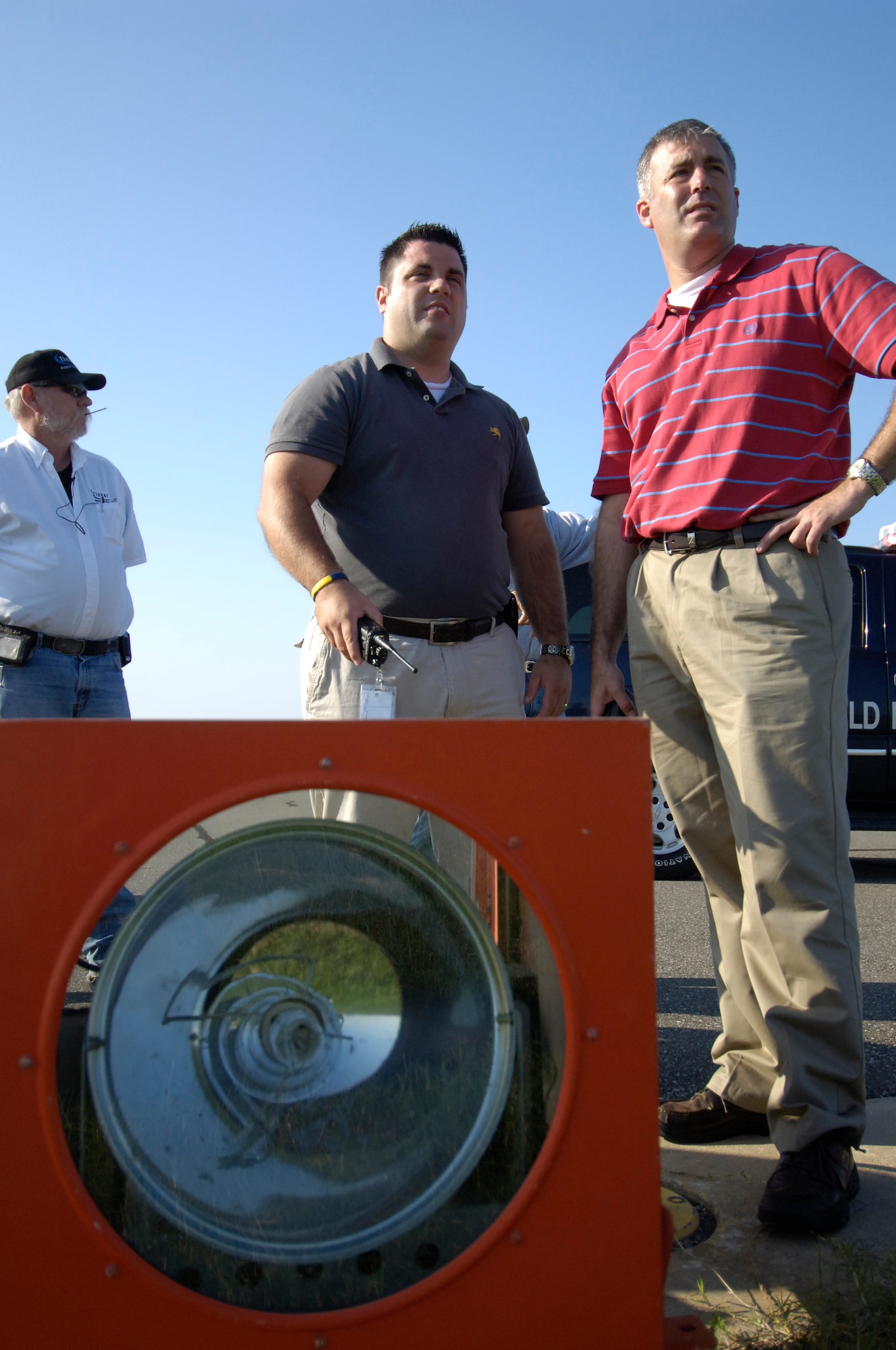 Benjamin Barker, center, airfield manager, and Marc Bradley, airfield operations manager, right, are two members of a team that helps keep Tinker’s airfield running safely and smoothly. They are working with contractors to survey the work about to begin on the runway’s sequence flashing lights.  (Air Force photo by Margo Wright)