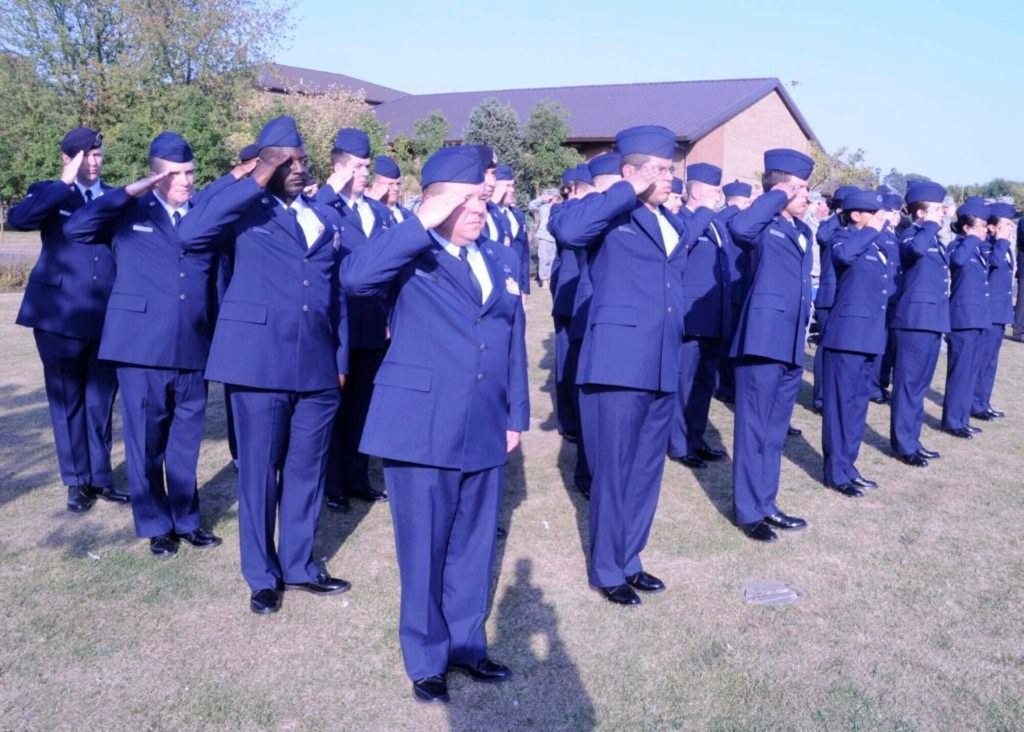 A flight of Airmen salute as the American and British national anthems play at the POW/MIA Week closing retreat ceremony Sept. 18, 2009, at Memorial Park on RAF Lakenheath, England. The retreat ceremony signified the end POW/MIA Week. (U.S. Air Force photo/Airman 1st Class Eboni Knox)