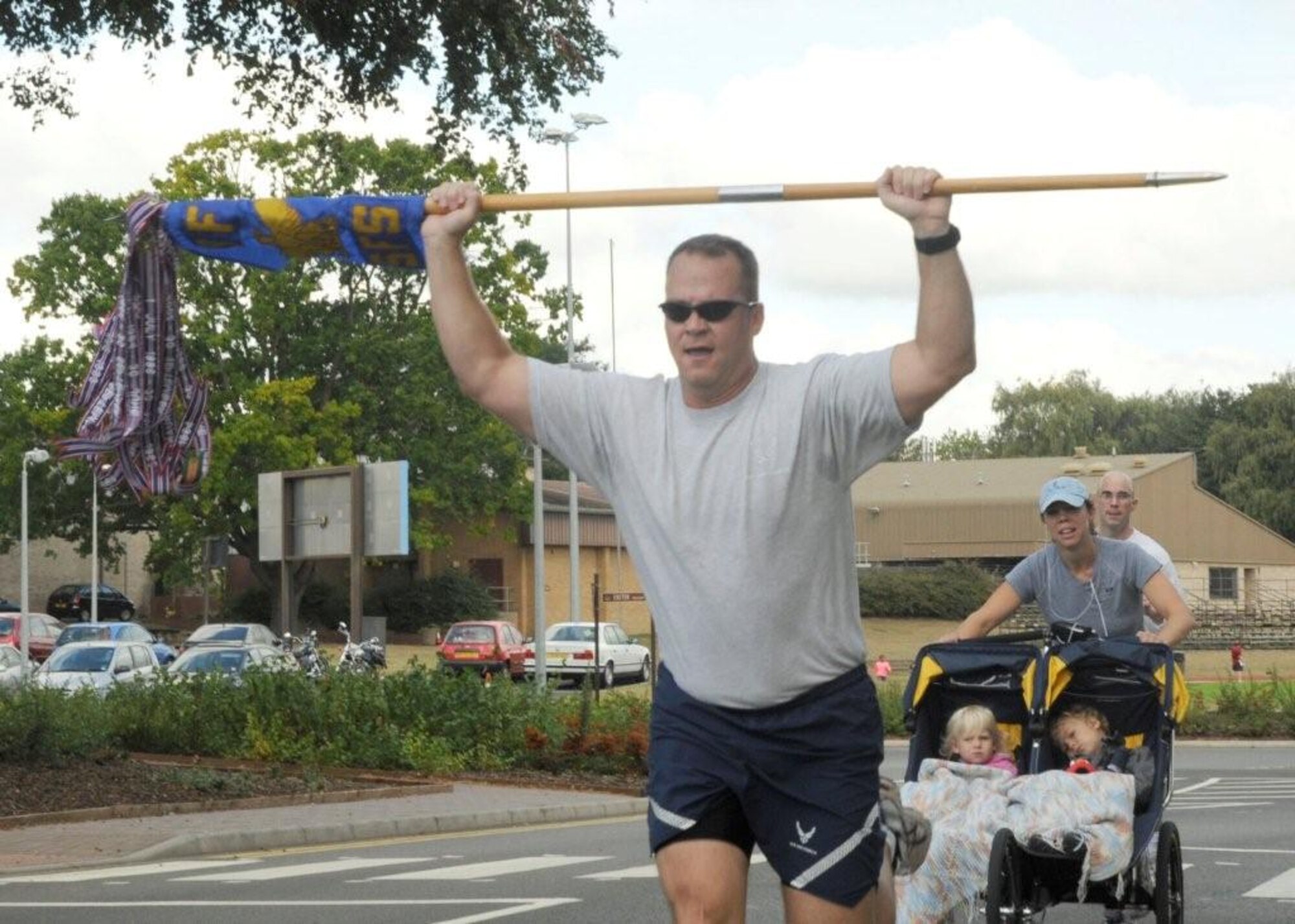 Lt. Col. Michael Ross, 48th Security Forces Squadron commander, holds the 48th SFS guidon over his head as he crosses the finish line of the 5K POW/MIA run, Sept. 16, 2009, at RAF Lakenheath, England. The 5K run was one of many events that took place during the POW/MIA Remembrance Week. (U.S. Air Force photo/ Airman 1st Class Eboni Knox))
