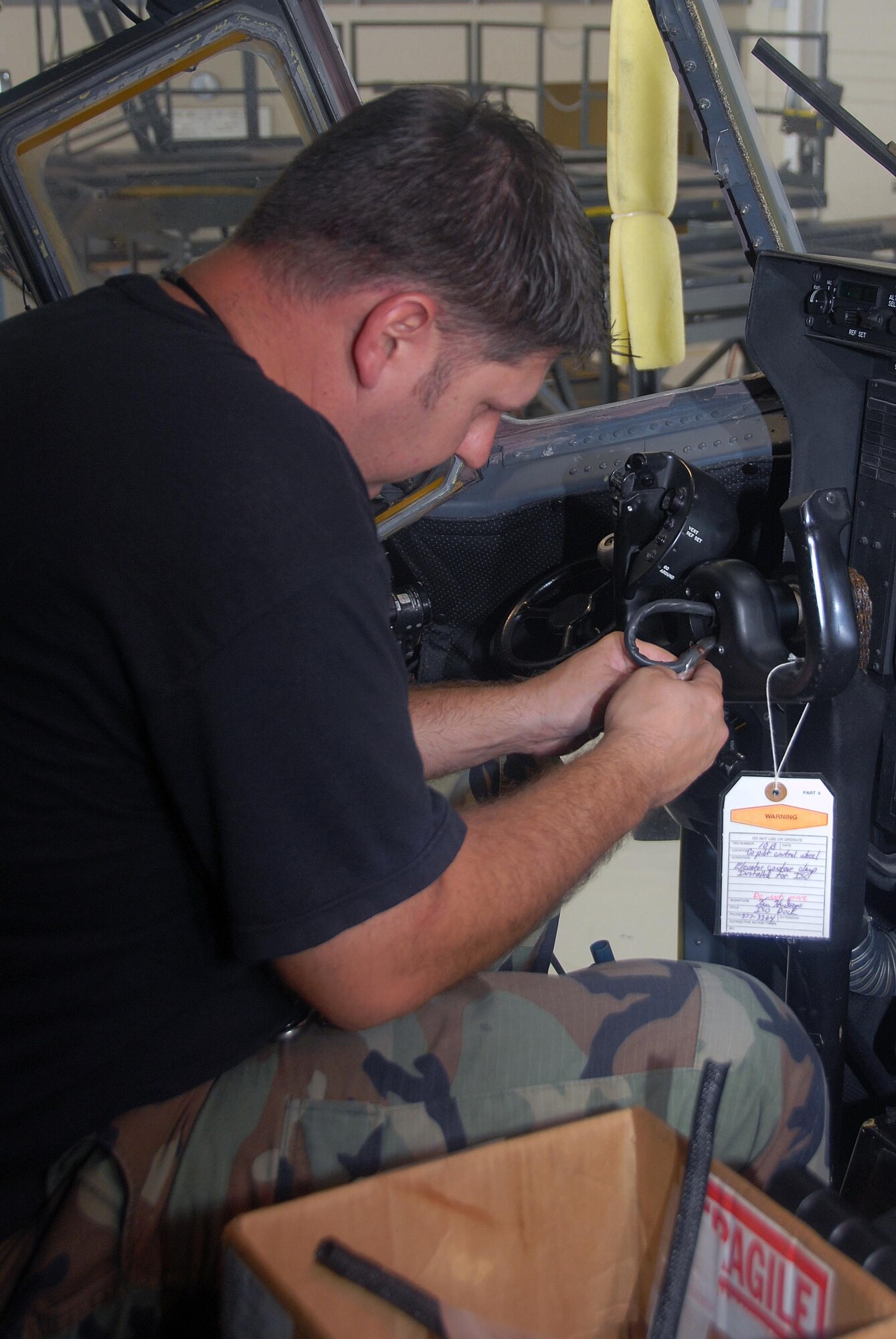 Senior Airman Mike Stansbury, 403rd Maintenance Group, cuts old coverings off of wires in the control wheel of a C-130J. This electrician is replacing the covering to keep wires in the wheel from wearing out. (U.S. Air Force Photo by Senior Airman Tabitha Dupas)