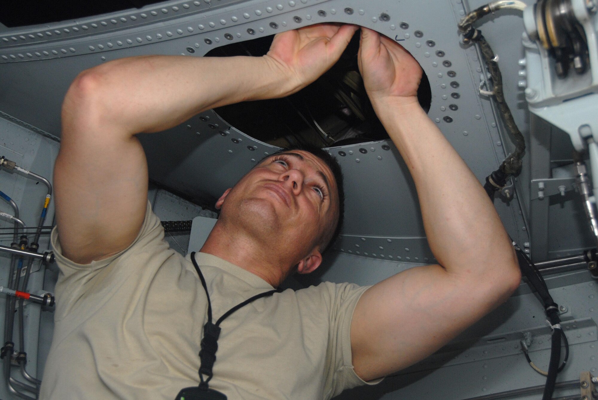 Senior Airman Harlon Patton, 403rd Maintenance, is adjusting wires in the front landing gear well of a C-130J. Airman Patton works in avionics and is preparing the plane so the electrical shop can complete their work on the control wheel in the flight deck. The different shops often use teamwork to maintain a safe aircraft. (U.S. Air Force Photo by Tabitha Dupas)