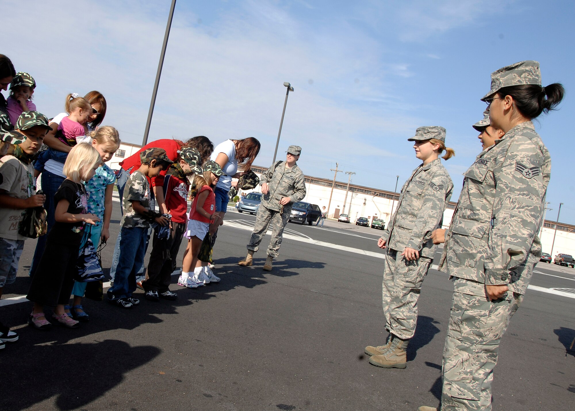 Airmen from the 22nd Medical Group show Team McConnell family members how to stand at attention, Sept. 19, 2009, at McConnell Air Force Base, Kan. The Airmen demonstrated military customs, courtesies and traditions for children during a mock mobility line event designed to share the pre-deployment process with Air Force family members. The McConnell Airman and Family Readiness Center hosted the event. (U.S. Air Force photo/Senior Airman Anthony Mejia)