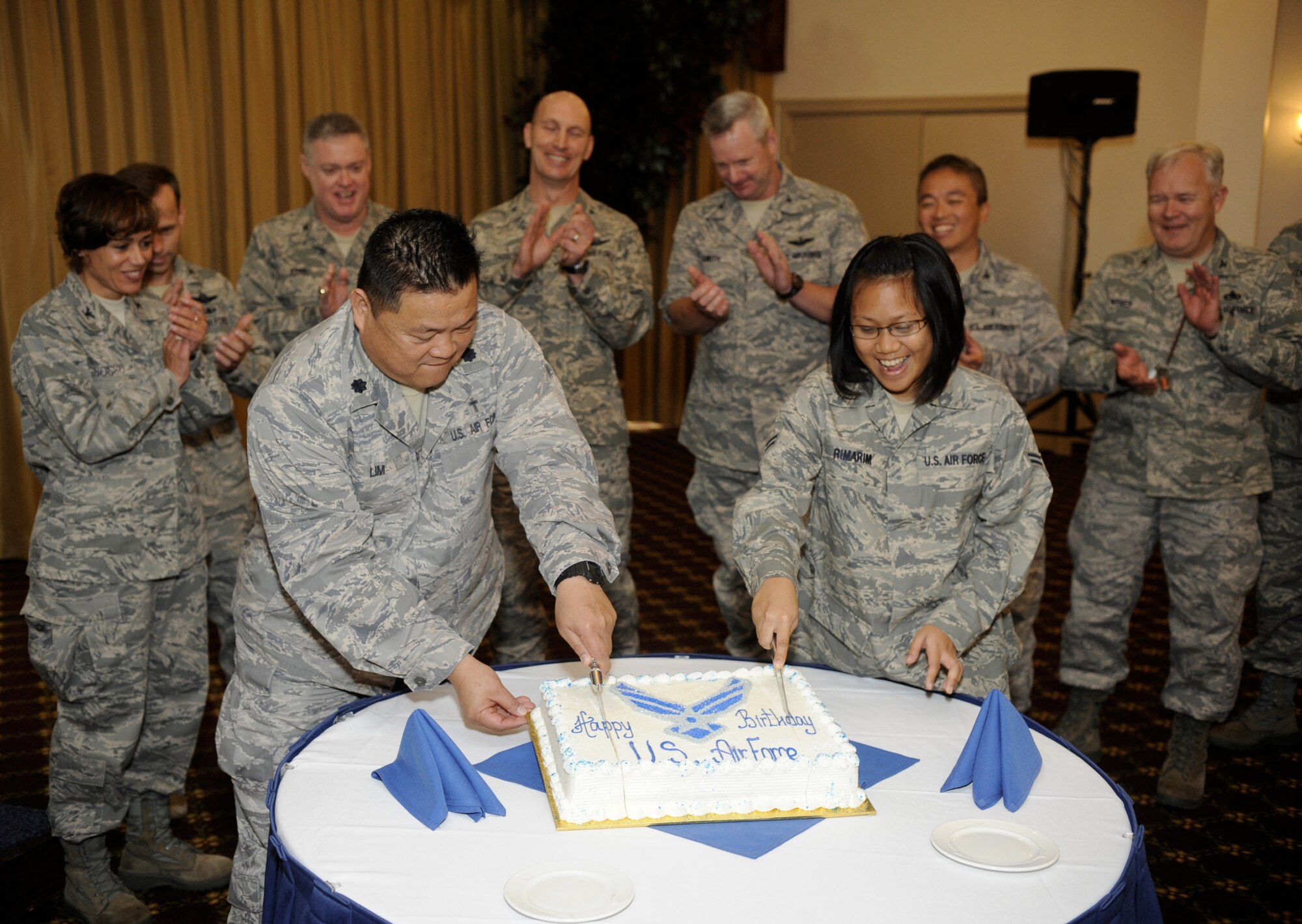 Lt. Col. Joseph Lim, 87th Air Base Wing, and Airman 1st Class Peaches Rimarim, 87th Logistics Squadron, cut the first slice of cake, at the Air Force’s 62nd birthday celebration Sept. 18 at the community center here. In line with tradition, Colonel Lim held the honor of being the oldest of the members present, while Airman Rimarim was the youngest.(U.S. Air Force photo/Carlos Cintron)