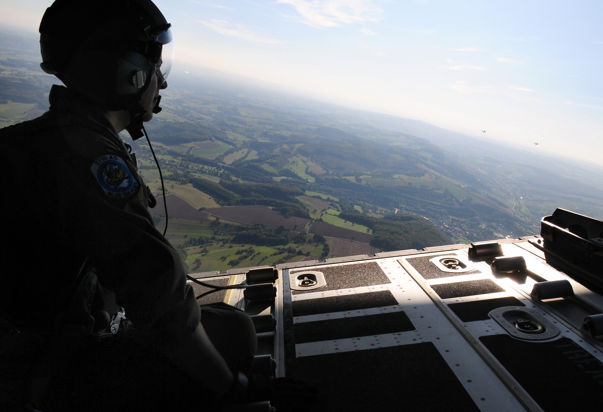 U.S. Air Force Staff Sgt. Francesco "Ace" Ventura, a C-130 loadmaster assigned with the 37th Airlift Squadron, sits on a C-130J ramp as he watches the historic last mission involving a C-130 J and C-130E flying together from Ramstein AB, Germany, Sept 23, 2009. (U.S. Air Force photo by Staff Sgt. Jocelyn Rich)