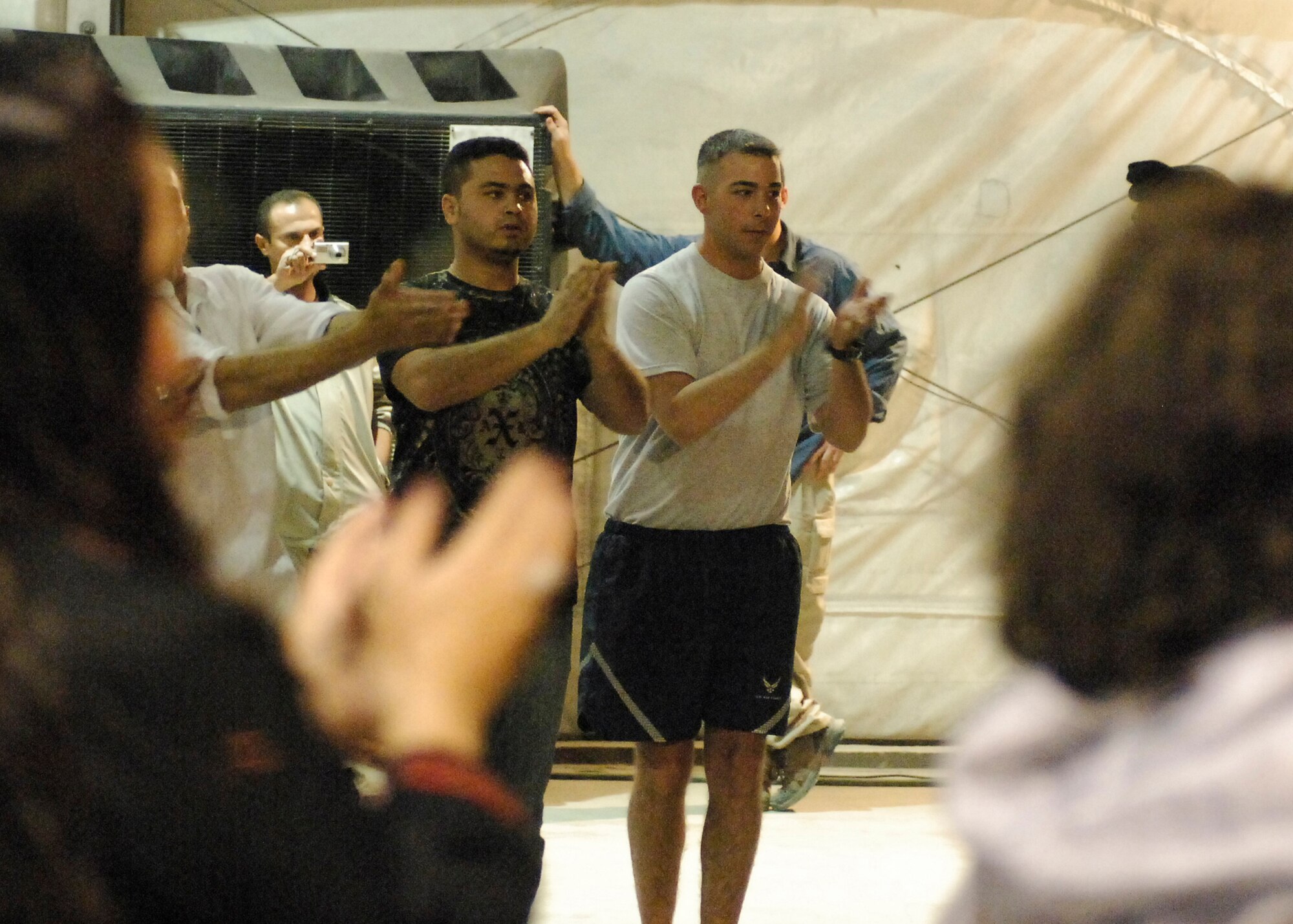 BAGRAM AIRFIELD, Afghanistan -- Staff Sgt. Robert Woltman, a 955th Air Expeditionary Squadron/Provost Marshal Office member, learns a dance from the Afghan locals during a celebration of Eid ul-Fitr, the Muslim feast that marks the end of fasting for Ramadan here, Sept. 22, 2009.  Ramadan is the Islamic month of fasting, in which participating Muslims refrain from eating, drinking, smoking, and indulging in anything that is in excess or ill-natured from dawn until sunset.  Sergeant Woltman is deployed from Dover Air Force Base, Del., and hails from Jacksonville, Fla.  When asked how he felt about the celebration Sgt Woltman said "I think it's great to show the unity of the American and Afghan people during a celebration such as Eid."  (U.S. Air Force photo/Senior Airman Felicia Juenke)