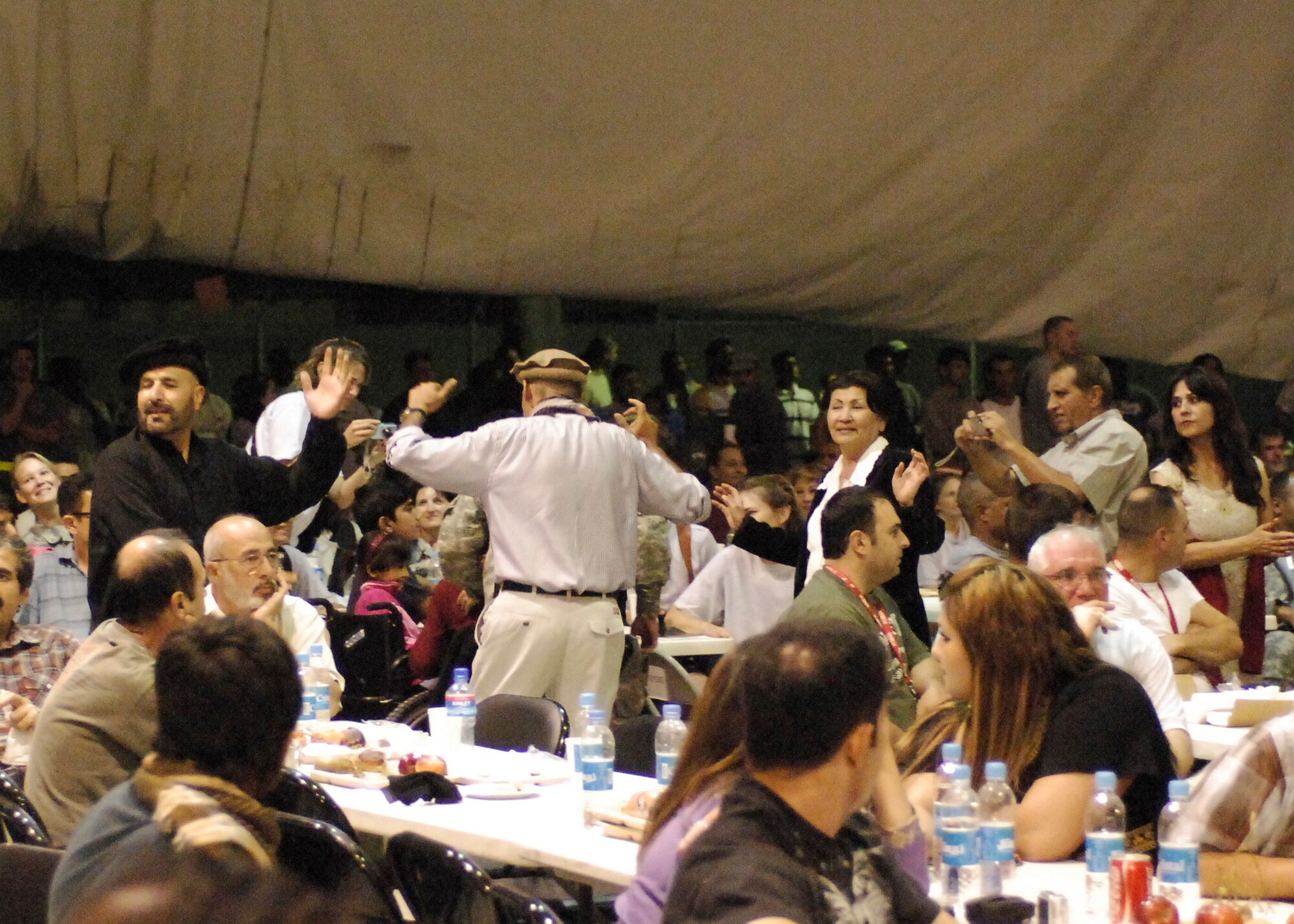 BAGRAM AIRFIELD, Afghanistan -- Afghan locals, Department of Defense civilians, as well as U.S. and coalition forces dance to Afghan music during a celebration of Eid ul-Fitr, the Muslim feast that marks the end of fasting for Ramadan here, Sept. 22, 2009.  Ramadan was the month in which the first verses of the Qur'an were claimed to have been revealed to the Prophet Muhammad.  During Ramadan, Muslims ask forgiveness for past sins, pray for guidance and help in refraining from everyday evils, and try to purify themselves through self-restraint and good deeds.  (U.S. Air Force photo/Senior Airman Felicia Juenke)