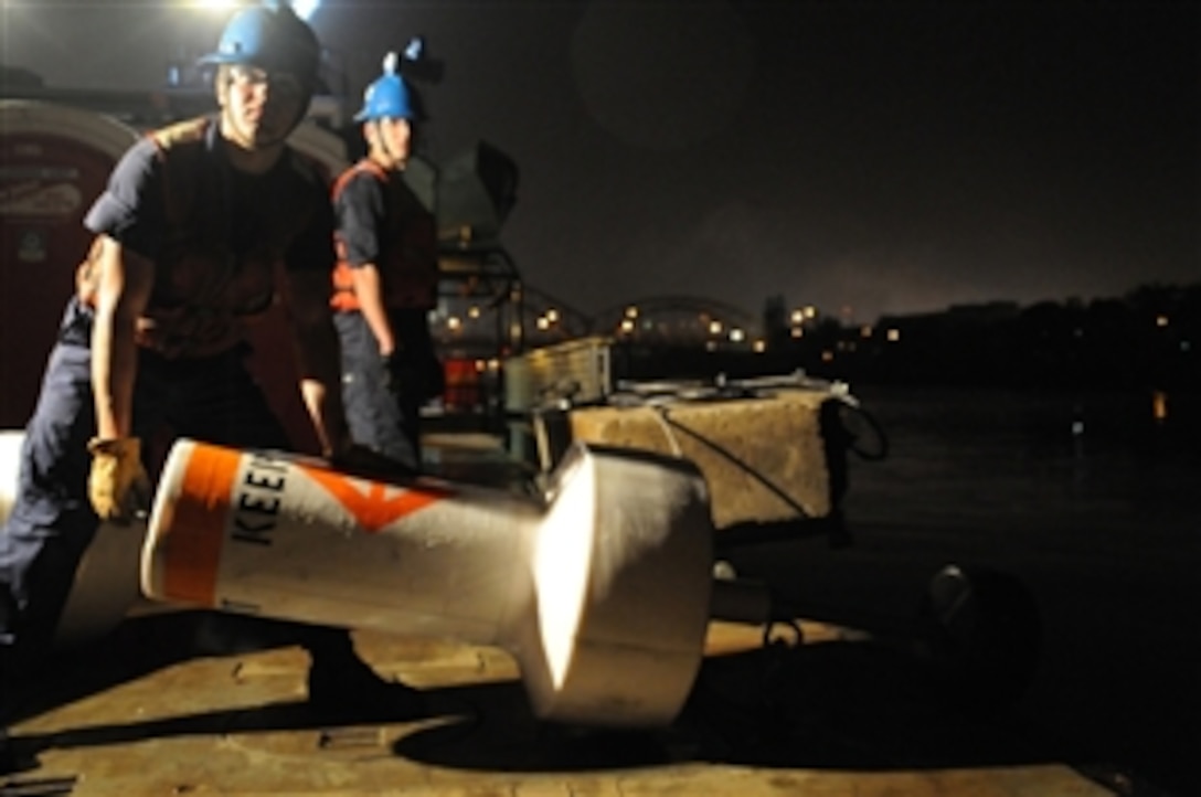 U.S. Coast Guard Seamen Eric Dahl and Adam Pierce position a buoy along the Allegheny River in Pittsburgh, Pa., Sept. 24, 2009. The crew of USCGC Osage is positioning the buoys to give mariners a clear picture of the security boundary. 