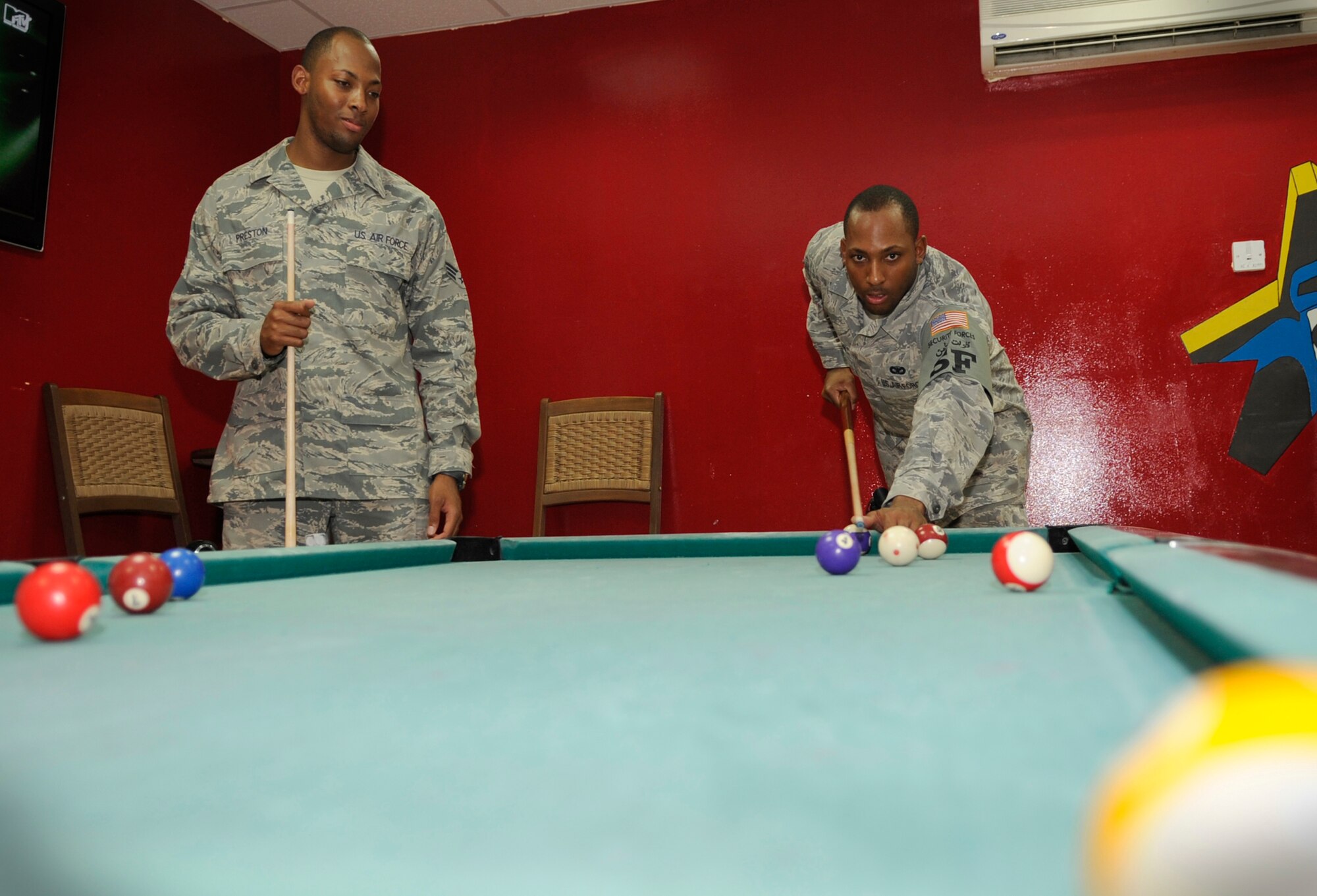 SOUTHWEST ASIA – Staff Sgt. Bryant Preston, 380th Expeditionary Security Forces Squadron, plays a game of pool with his twin brother, Senior Airman Erik Preston, 380th Expeditionary Logistics Readiness Squadron, while on his lunch break here recently. The brothers met at the 380th Air Expeditionary Wing for the first time in more than three years. (U.S. Air Force photo/Senior Airman Stephen Linch)