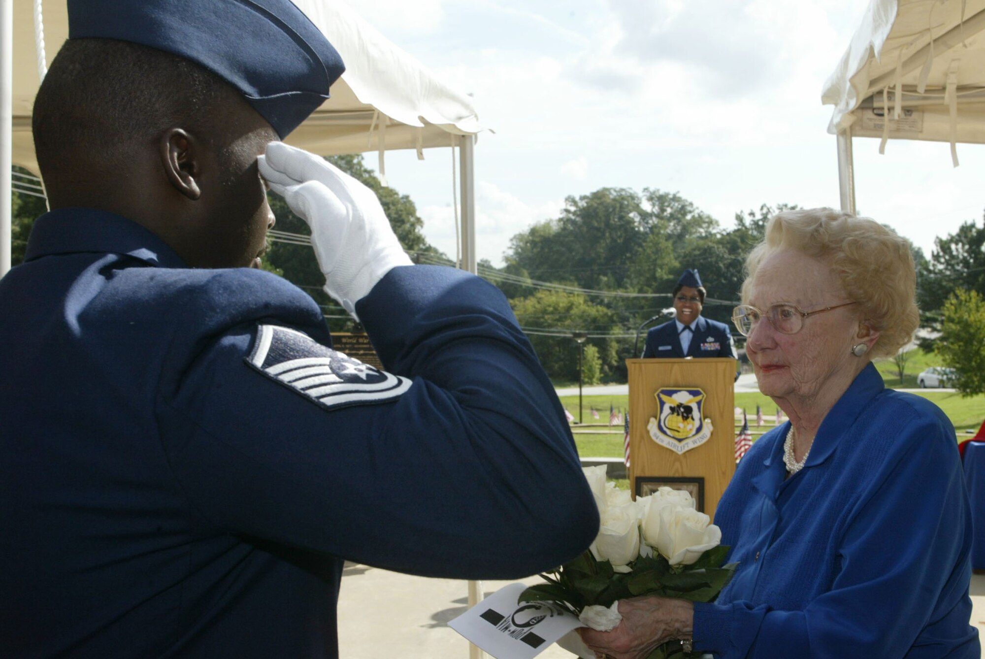 Master Sgt. George E. Atkinson, instructor, Transportation Proficiency Center presents white roses to Mrs. Christine Jones, mother of Maj. Bobby Jones, flight surgeon and Vietnam Veteran at the Dobbins 25th Annual Living Memorial Ceremony Sept. 25. Major Jones has been missing in action since Nov. 28, 1972. (U.S. Air Force photo/Don Peek)