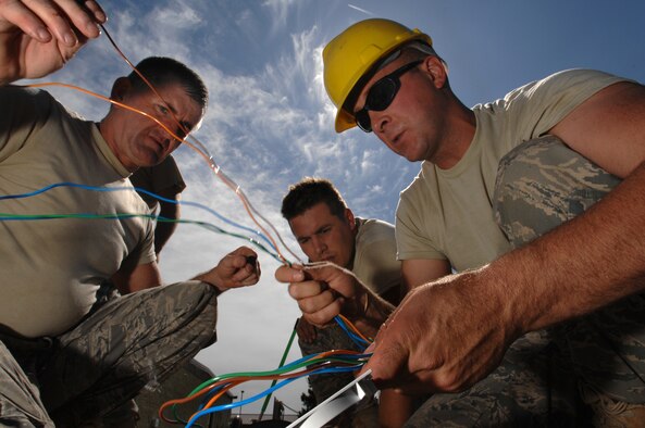 WHITEMAN AIR FORCE BASE, Mo. - U.S. Air National Guardsmen Staff Sgt. Darry Walker (left), Staff Sgt. Dustin Sims and Master Sgt. Mike Leddy, all 217th Engineering Installation Squadron, Springfield, Ill., unravel and inspect fiber optic cable prior to splicing it to fuse together with a different set of fiber optic cable, Sept. 24. Air National Guard members from the 271st and the 241st have spent more than two months at Whiteman replacing copper transmission cable with more efficient fiber optic cable. The fiber optic cable will provide 50 percent more capability and expansion to utilize a greater number of networked products. (U.S. Air Force photo/Senior Airman Kenny Holston)