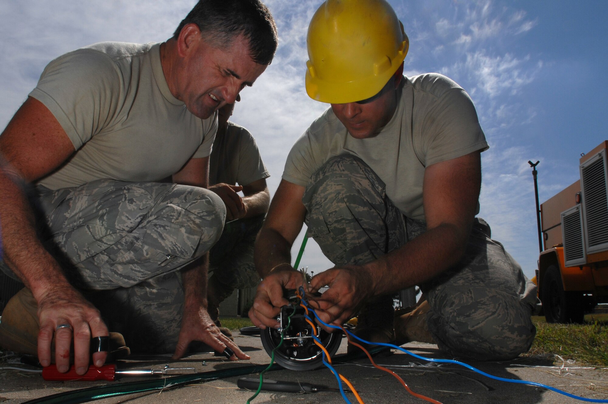 WHITEMAN AIR FORCE BASE, Mo. - U.S. Air Force Guards men, Staff Sgt. Darry Walker (left), and Master Sgt. Mike Leddy, both 217th Engineering Installation Squadron, Springfield, Ill., separate colored stands of fiber optic cable to determine which stands need to be spliced Sept. 24. Air National Guard members from both the 271st and the 241st have spent more than two months at Whiteman AFB replacing copper transmission cable with more efficient fiber optic cable. The fiber optic cable will provide 50 percent more capability and expansion to utilize a greater number of networked products. (U.S. Air Force photo/ Senior Airman Kenny Holston)