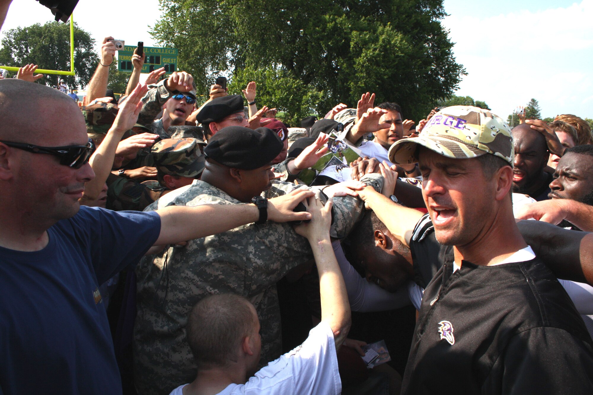 Sharing a warrior spirit, members of the United States military huddled with Baltimore Ravens head coach, John Harbaugh and Ravens football players during the traditional after-practice huddle.  Military members were the guests of the Ravens during a Military Appreciation Day on August 19, 2009. (U.S. Air Force photo by MSgt. Lou DeVeaux, 175th Wing Public Affairs, Warfield Air National Guard Base, Maryland, United States)  
