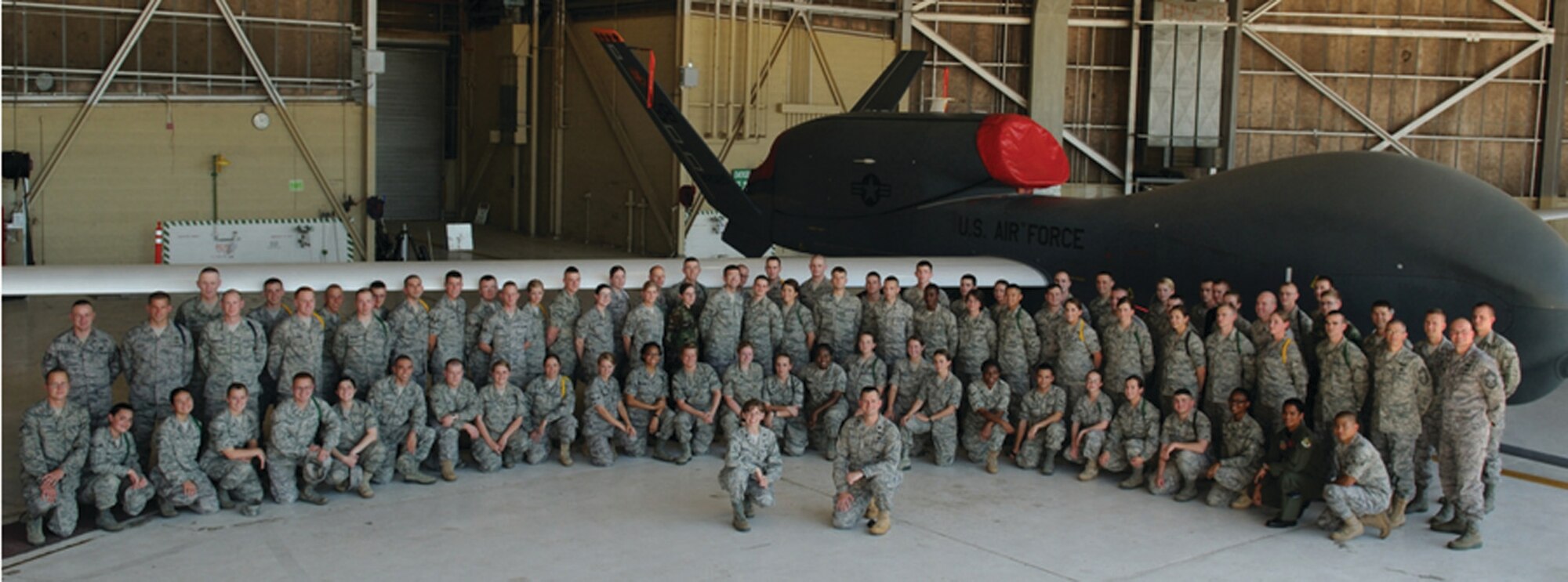 Presidio of Monterey Airmen pose in front of an RQ-4 Global Hawk aircraft, Beale Air Force Base, Calif, Sept. 3, (U.S. Air Force photo by Staff Sgt. Rebecca Reep, Staff Sgt. Aaron Oelrich, Staff Sgt. Jeremy McGuffin and  Airman 1st Class  Christina Egge )
