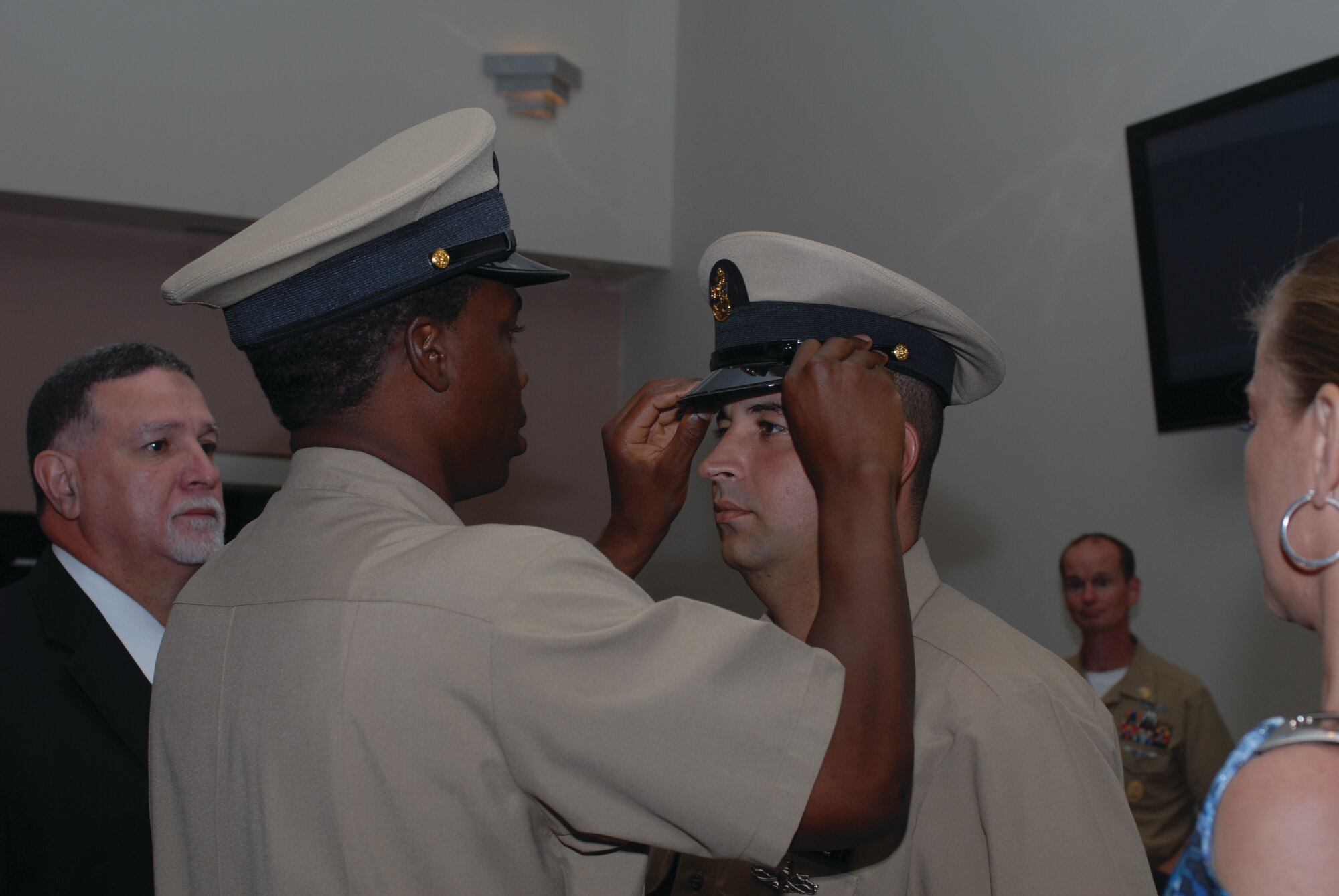 Chief Petty Officer Sean Thomas, Center for Information Dominance Detachment, places the chief’s hat on Chief Petty Officer Jose Suarez III, after his promotion, Sept. 16, at the Event Center. (U.S. Air Force photo by Staff Sgt. Laura R. McFarlane)