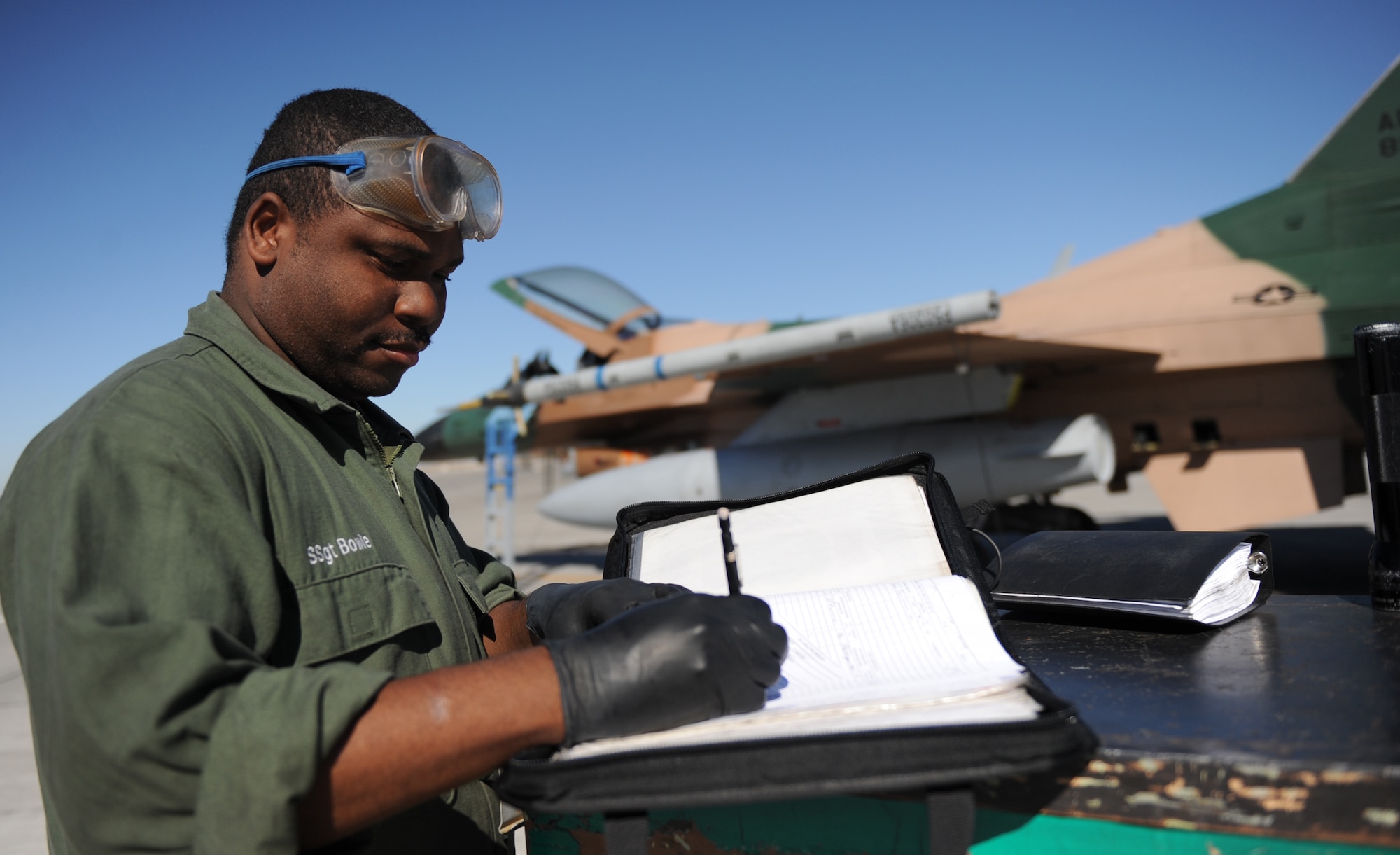 MOUNTAIN HOME AIR FORCE BASE, Idaho -- Staff Sgt. Darryl Bowie, 57th Aircraft Maintenance Squadron crew chief our of Nellis AFB, Nev., prepares a checklist before performing maintenance on an F-16 Fighting Falcon from the 64th Aggressor Squadron Sept. 23. With a mission to know, teach and replicate any threat friendly forces may face, the 64th AGS and their F-16 Fighting Falcons from Nellis AFB, Nev., represented enemy aircrews as “red air” participants during the exercise. Gunfighter Flag, which ran from Sept. 14 through 24, was Mountain Home’s first ever large-scale, multi-national exercise which brought more than 450 personnel from the U.S. Air Force, U.S. Navy and Canadian air force to Mountain Home. (U.S. Air Force photo by Airman 1st Class Renishia Richardson) 