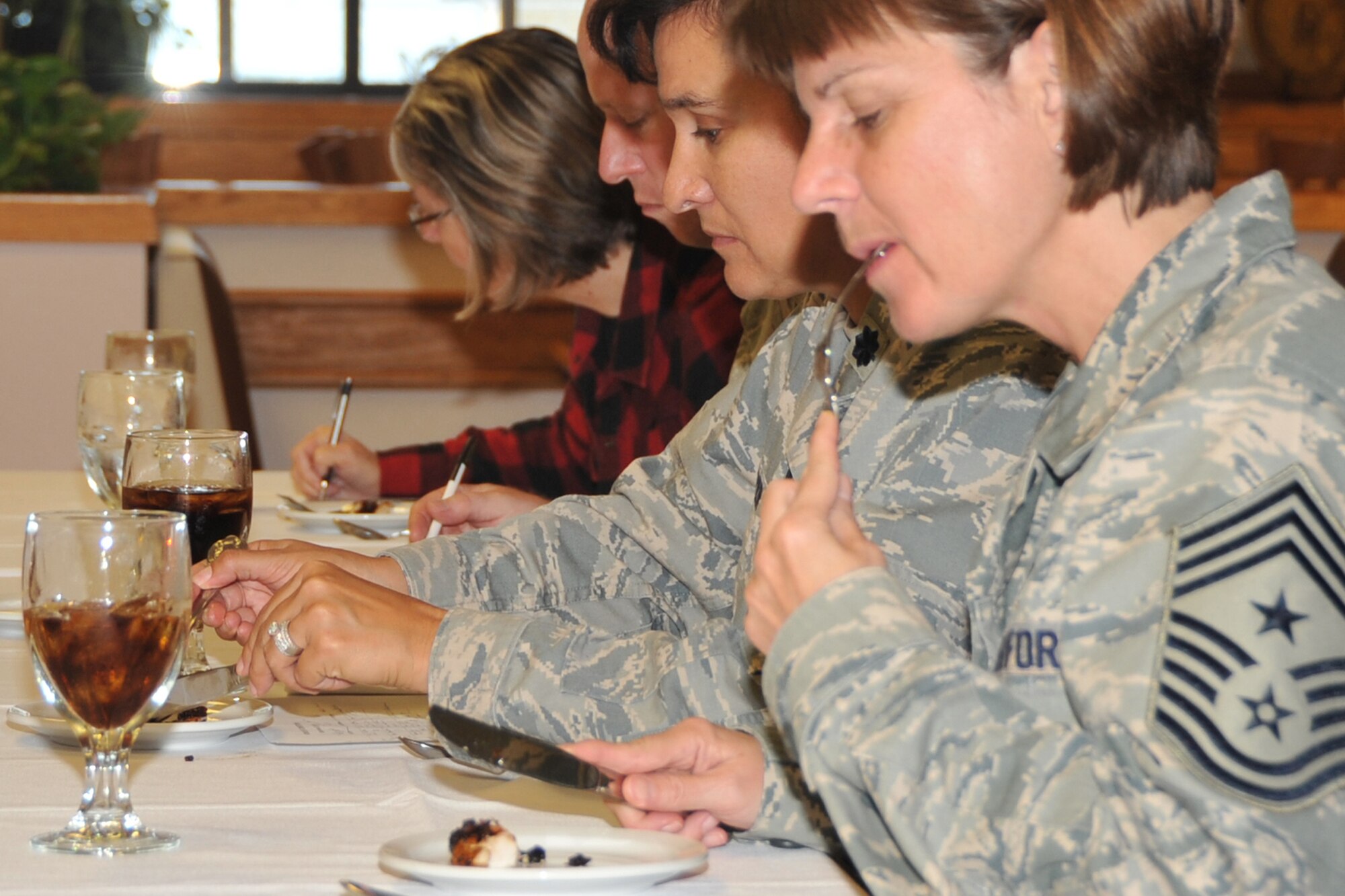 OFFUTT AIR FORCE BASE, Neb. - Chief Master Sgt. Lisa Sirois, 55th Wing Command Chief, takes a bite from an appetizer while judges Collen Kleek, from Hell's Kitchen, Col. Michael Allshouse, 55th Mission Support Group commander,  and Lt. Col. Denise Cooper, 55th Force Support Squadron commander, write down comments during the Iron Chef Competition held at the King Dining Facility Sept. 23. The three teams of chefs prepared appetizers, a main course and desert dishes for judges to score. Each team was awarded a day off for their participation and the winning team was awarded two days off. U.S. Air Force photo by Jeff W. Gates.