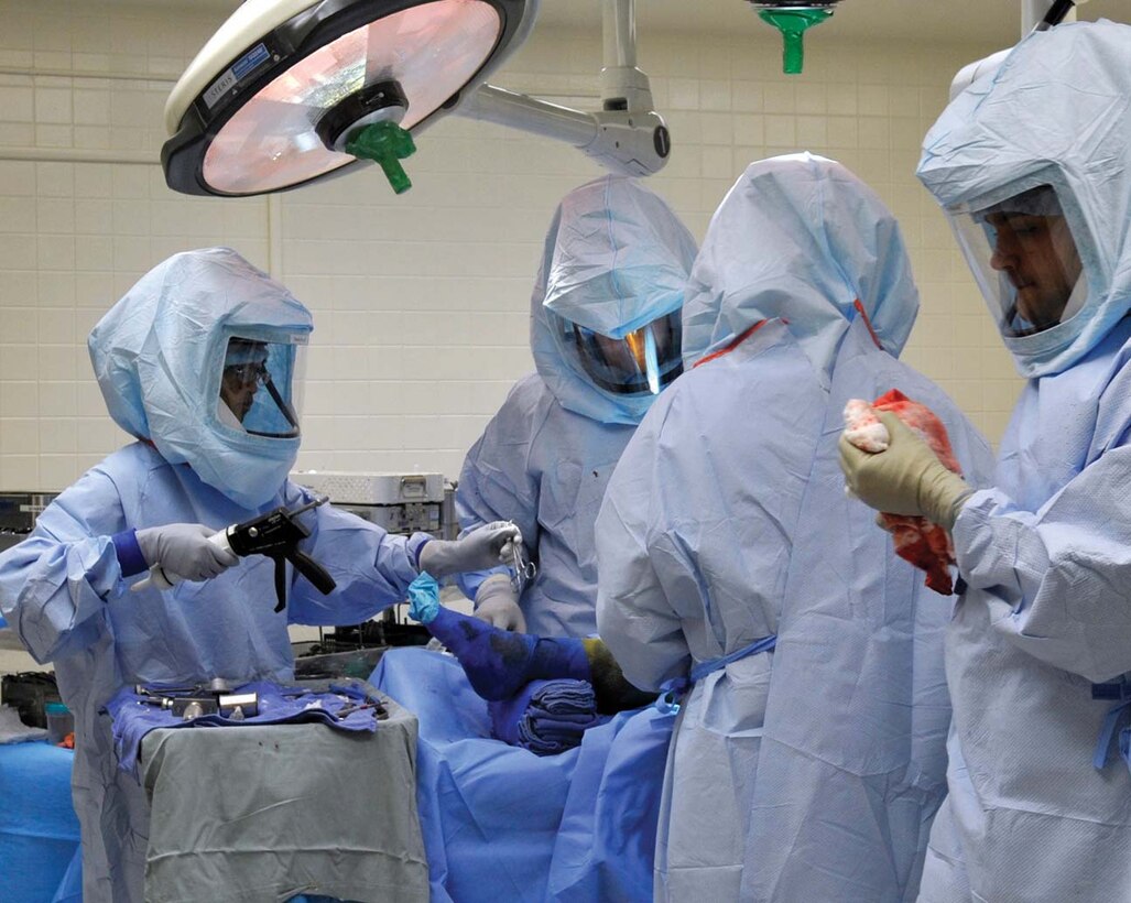 Airman 1st Class Bountai Chantala, left, and Airman 1st Class Ryan Harmening, far right, surgical technicians specializing in orthopedics with the 779th Surgical Operations Squadron, assist with a total knee arthroplasty at Malcolm Grow Medical Center, Sept. 14. During surgery, the technicians pass instruments, sutures and sponges as well as perform a variety of other tasks depending on the surgeon’s needs. (U.S. Air Force photo/ Staff Sgt. Renae Kleckner)