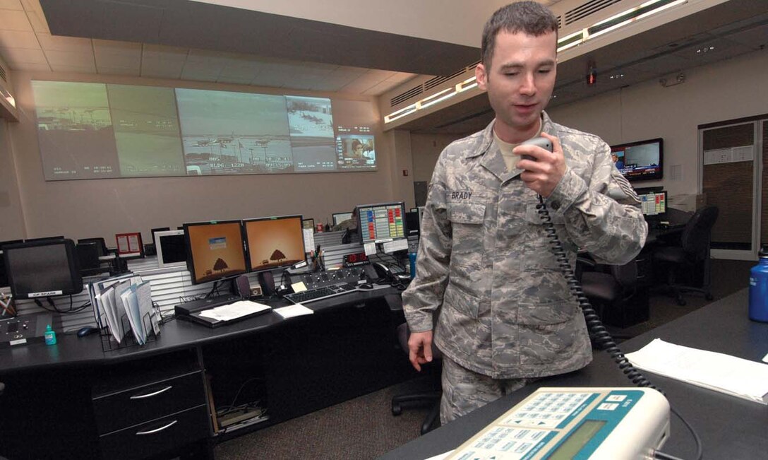 Technical Sgt. Joseph Brady, NCO in charge of console operations for the Andrews Regional Command Post and 316th Wing Command Post, uses the Giant Voice machine to conduct a random test from inside the Base Operations Command Post building. The command post uses the Giant Voice for mass alert should the base come under threat of attack or natural disaster.(U.S. Air Force photo/ Bobby Jones)