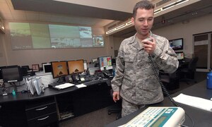 Technical Sgt. Joseph Brady, NCO in charge of console operations for the Andrews Regional Command Post and 316th Wing Command Post, uses the Giant Voice machine to conduct a random test from inside the Base Operations Command Post building. The command post uses the Giant Voice for mass alert should the base come under threat of attack or natural disaster.(U.S. Air Force photo/ Bobby Jones)