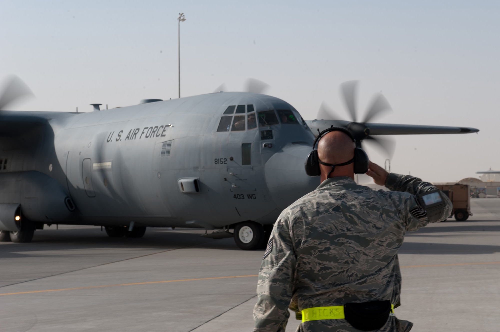 Tech. Sgt. Starky Hicks, 746th Expeditionary Aircraft Maintenance Unit crew chief, renders a salute to the flight commander of a C-130J as it takes off on a mission in Southwest Asia, Sept. 22. The 746 EAMU supports deployed C-130Js which provide intra-theater combat airlift support throughout Southwest Asia. Sergeant Hicks is deployed from Keesler Air Force Base, Miss. (U.S. Air Force photo/Staff Sgt. Robert Barney)