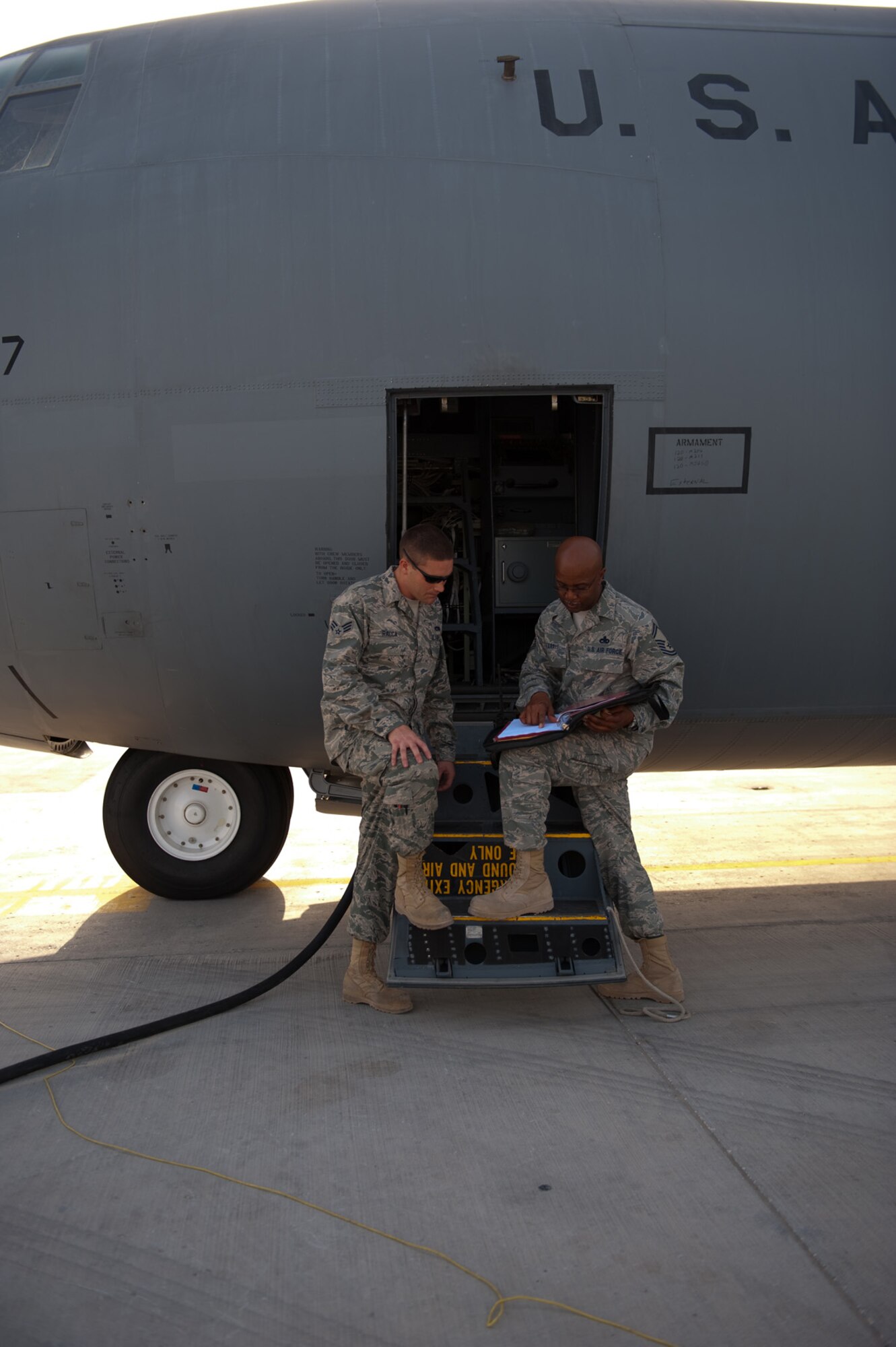Left, Senior Airman Tyler Racca assists Senior Master Sgt. Marshall Harris, both assigned to the 746th Expeditionary Aircraft Maintenance Unit, with a final check on all required maintanence prior to a C-130J mission take-off in Southwest Asia, Sept. 22. The 746 EAMU supports deployed C-130Js which provide intra-theater combat airlift support throughout Southwest Asia. (U.S. Air Force photo/Staff Sgt. Robert Barney) 