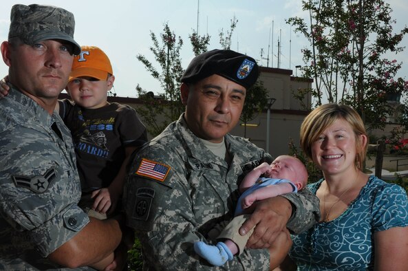 Airman 1st Class Christopher Perry of the 31st Maintenance Squadron, his wife Anna, 3-year-old son Brenden and one-month-old son Ty, pose with Army Staff Sgt. Ulisis Patino of the 99th Movement Control Team, Sept. 25, 2009 at Aviano Air Base, Italy. Sergeant Patino assisted Mrs. Perry during the delivery of her youngest son in the passenger seat of a friend's car in their neighborhood Aug. 18, 2009 in Maniago, Italy. (U.S. Air Force photo/Senior Airman Nadine Barclay)  