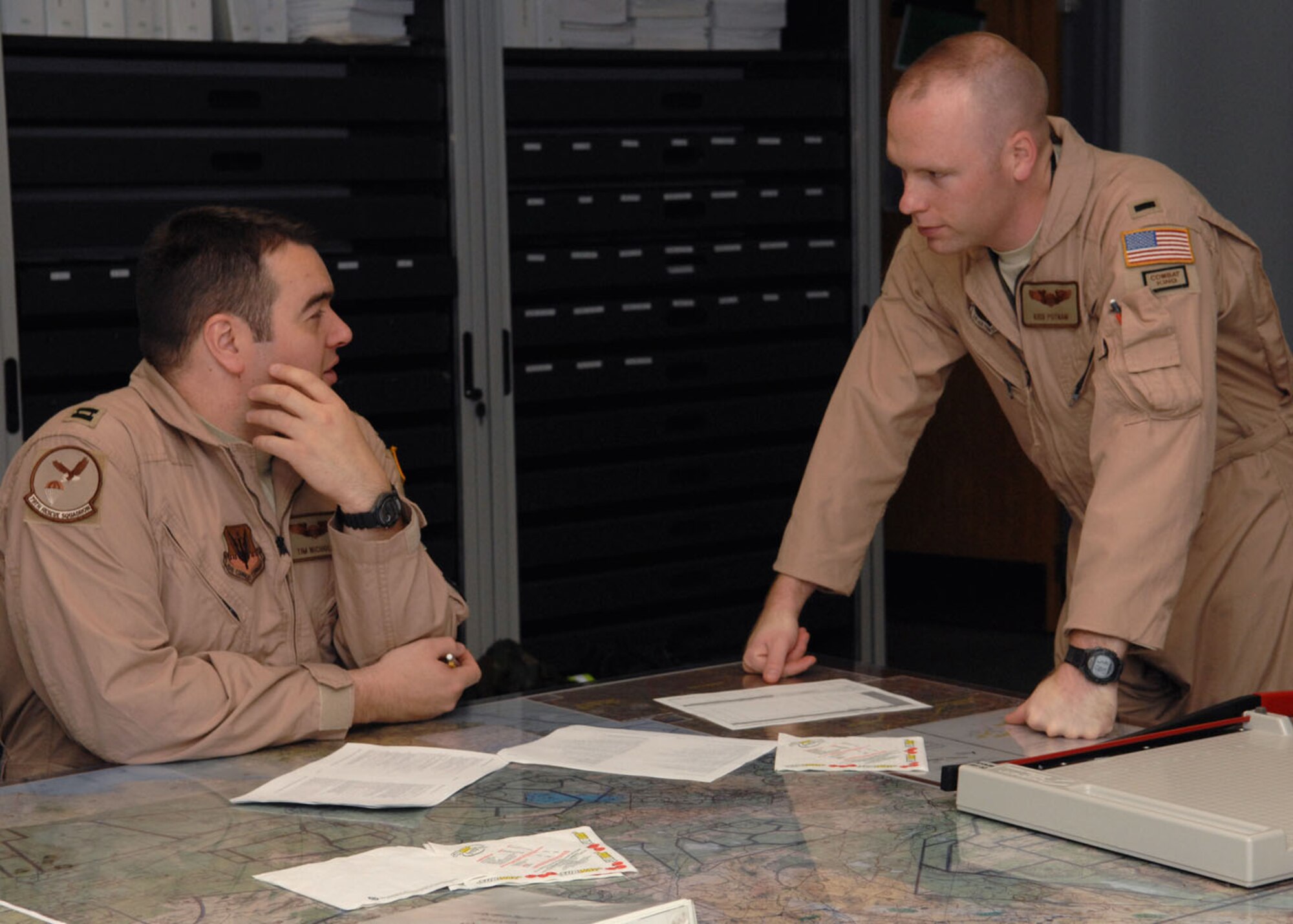Capt. Tim Nicholls and 1st Lt. Kris Putnam, both from the 79th Rescue Squadron, discuss details concerning their deployment to the Horn of Africa Sept. 23. (U.S. Air Force photo/Airman Jerilyn Quintanilla)