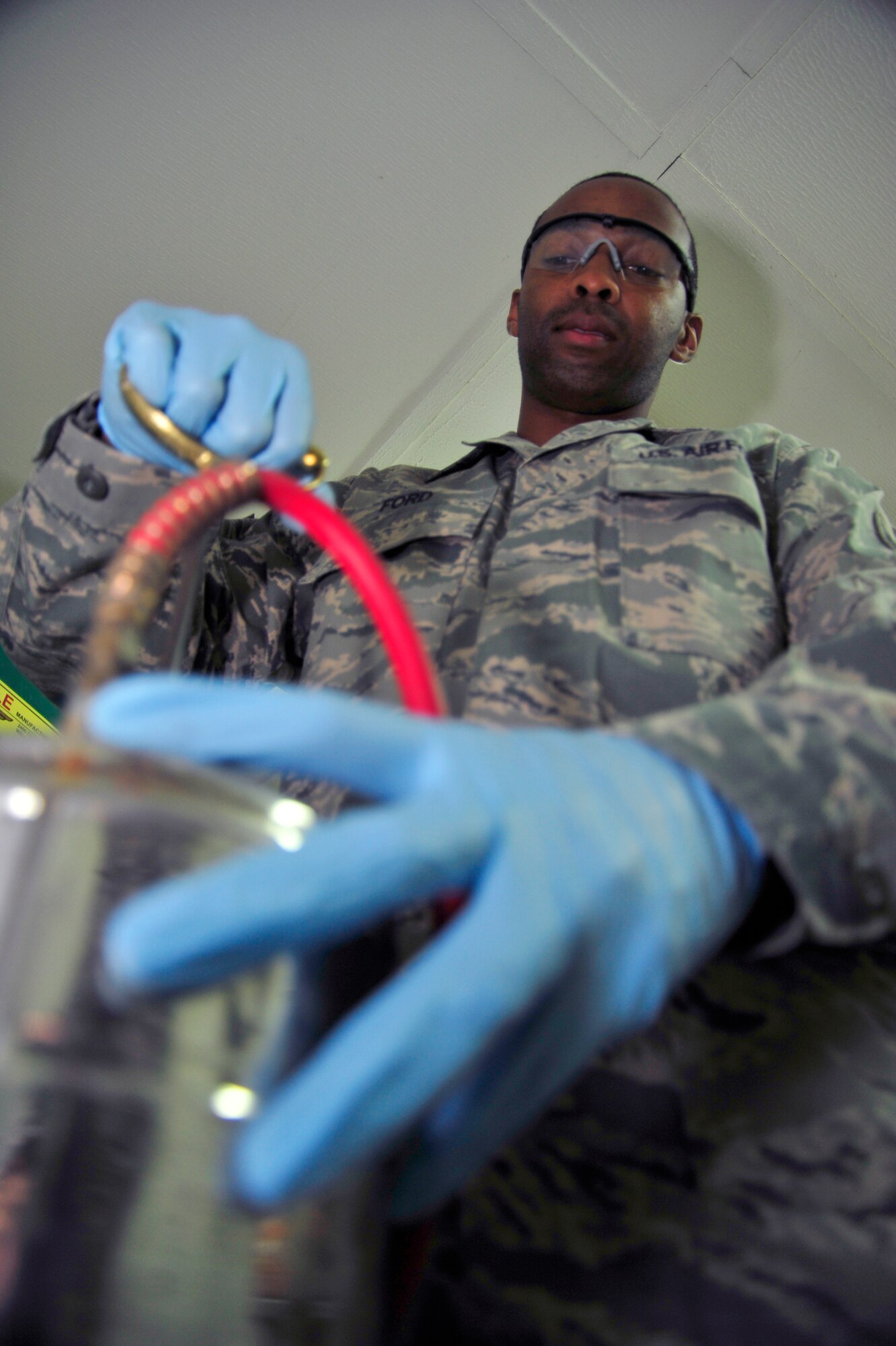 SOUTHWEST ASIA -Senior Airman Semorian Ford, 380th Expeditionary Civil Engineer Squadron, pest management journeyman, pressurizes a one-gallon sprayer filled with multi-use pesticide here Sept. 25, 2009. Airman Ford is stationed at Scott Air Force Base, Ill., and grew up in Tyler, Texas. (U.S. Air Force photo/Tech. Sgt. Charles Larkin Sr)