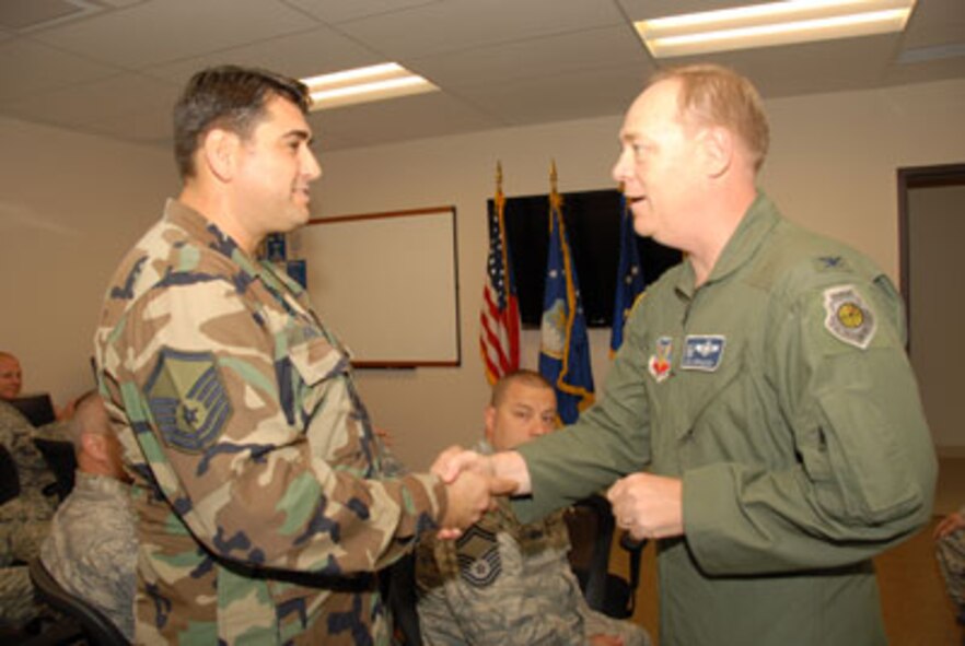 Col. Kevin W. Bradley, 174FW Commander presents Master Sgt. Michael Adams, 163rd Reconnaissance Wing March Air Reserve Base, Calif. with a 174FW unit coin on the 24th of September for overseeing and facilitating the first graduating class of the Ground Control Station maintenance course held here at Hancock Field Air National Guard Base. The first Air National Guard-run Formal Training Unit (FTU) class began on March 16, 2009 by the 163d RW, March Air Reserve Base, Calif. (U. S. Air Force photo by Staff Sgt. Barbara Olney/RELEASED)