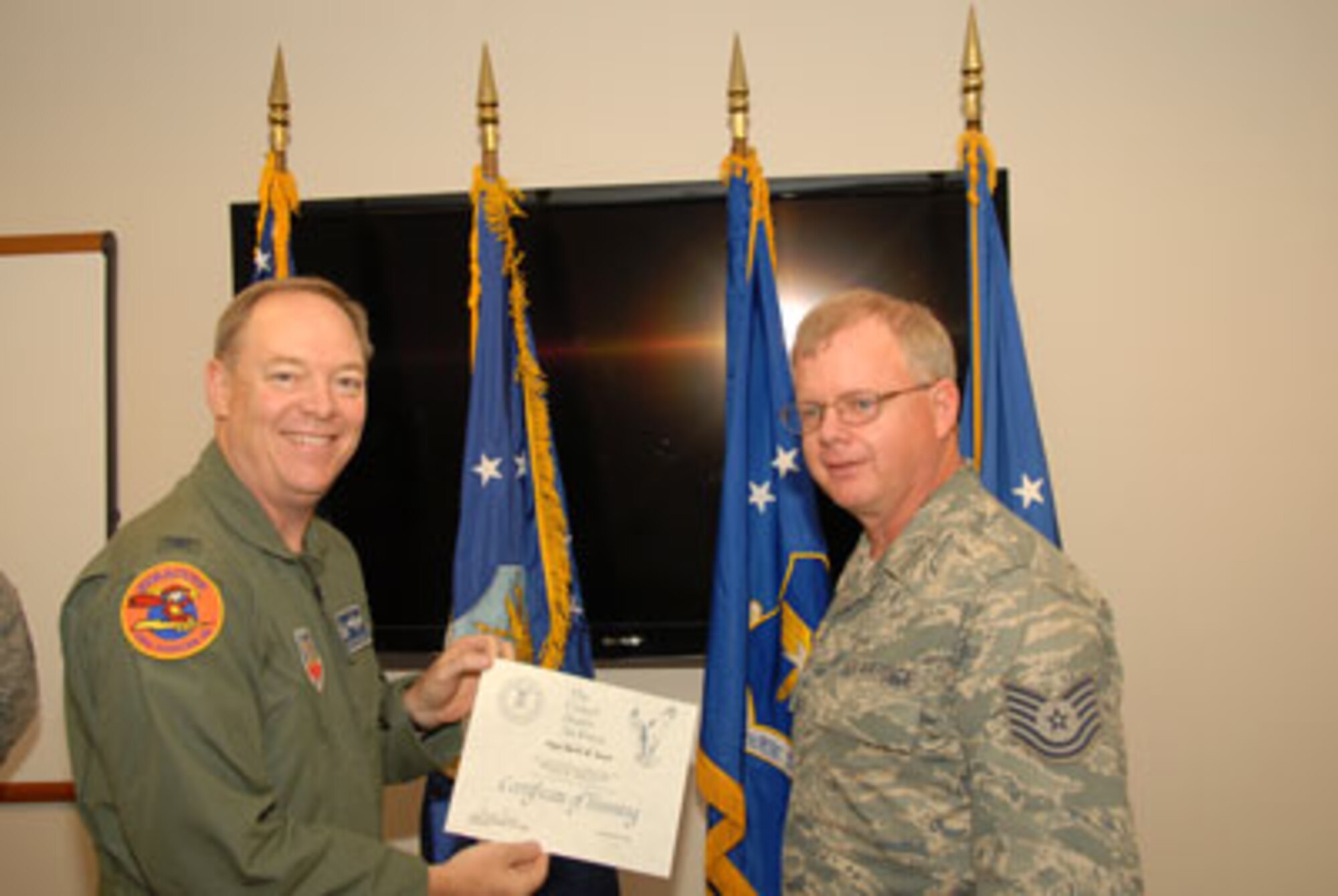 Col. Kevin W. Bradley, 174FW Commander presents Technical Sgt. Mark Raut with his certificate on the 24th of September as part of the first graduating class of the Ground Control Station maintenance course held here at Hancock Field Air National Guard Base. (U. S. Air Force photo by Staff Sgt. Barbara Olney/RELEASED)