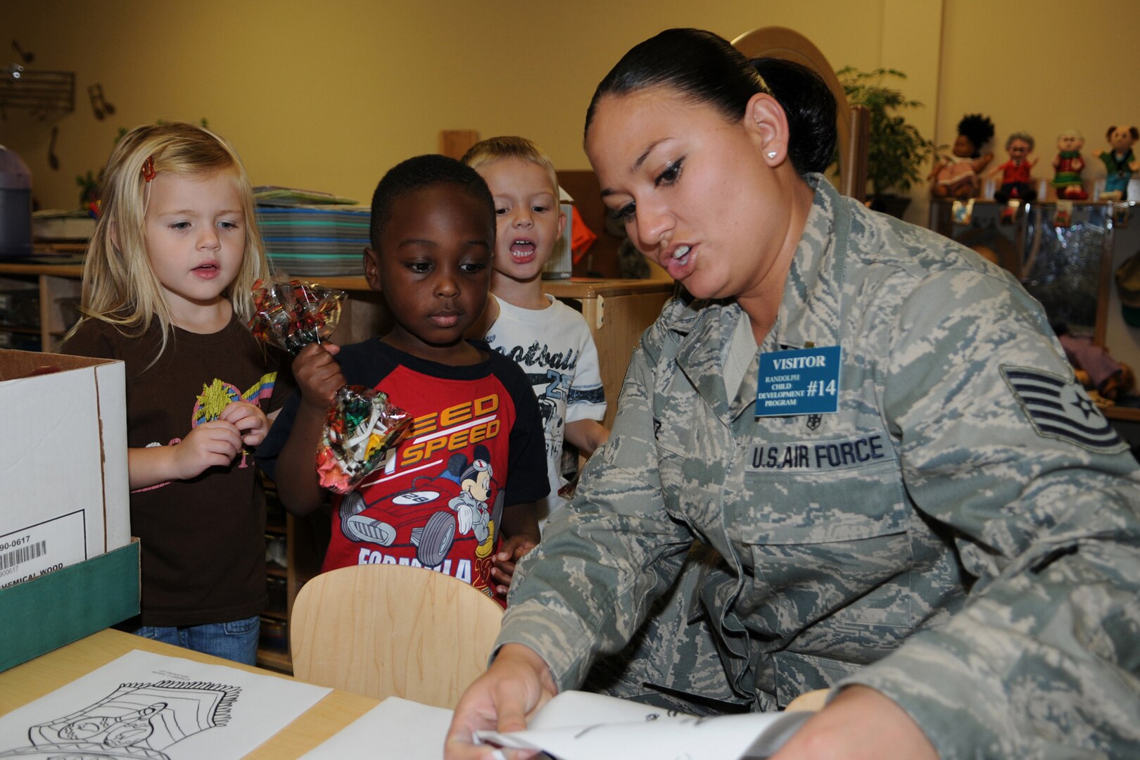 Tech. Sgt. Miriam Saiz, 12th Medical Group, prepares to give Breiland Dodd and Sean Nkya a picture to color after receiving prize during the Hispanic Heritage Month piñata party at the Randolph Child development Center Sept. 24.  (U.S. Air Force photo/Don Lindsey) 
