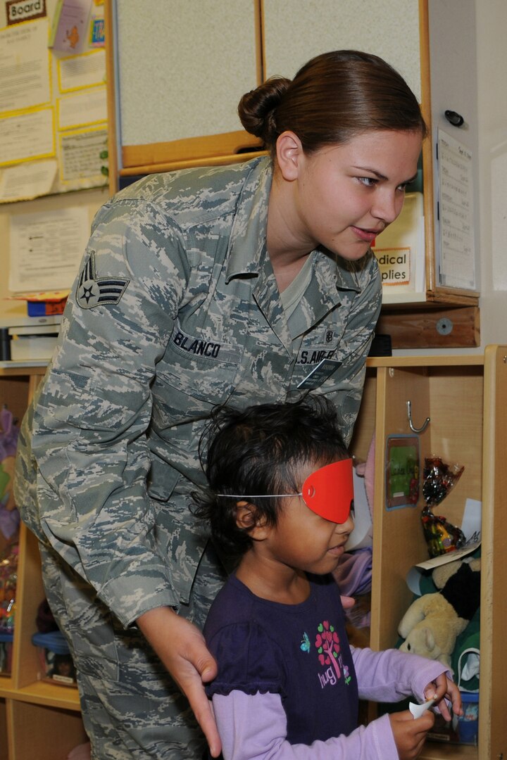 Senior Airman Brittney Blanco, 12th Medical Group, helps line Tiana Ramcharital, play pin the tail on the donkey during the Hispanic Heritage Month piñata party held at the Randolph Child Development Center Sept. 24.  (U.S. Air Force photo/Don Lindsey)