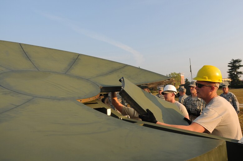 Staff Sgt. Nathon Wheat, 1st Combat Communications Squadron radio maintenance, inserts the final panel into the center hub of a USC-60 satellite Sept. 22, 2009 at Aviano Air Base, Italy, during a weeklong training exercise. Sergeant Wheat and other radio and satellite communications Airmen on his team, based out of Ramstein Air Base, Germany, conducted cross-flow training in preparation for their upcoming merger to the new transmission systems Air Force Specialty Code in October 2009. (U.S. Air Force photo/Staff Sgt. Patrick Dixon)