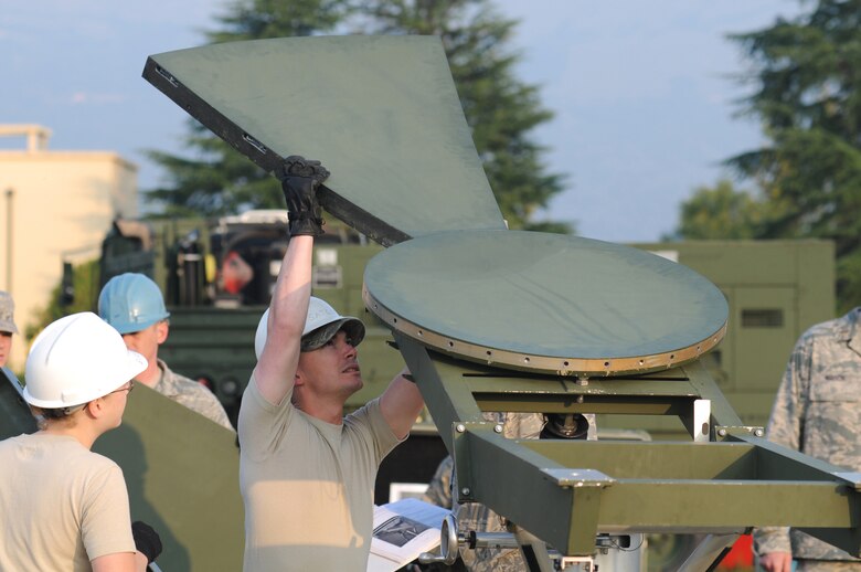 Tech. Sgt. Jonathan Gifford, 1st Combat Communications Squadron ground and radio maintenance, inserts the first panel into the center hub of a USC-60 satellite Sept. 22, 2009 at Aviano Air Base,  Italy. Sergeant Gifford and 19 other communications Airmen in eight different Air Force Specialty Codes from Ramstein Air Base, Germany, took part in the weeklong training exercise. (U.S. Air Force photo/Staff Sgt. Patrick Dixon)