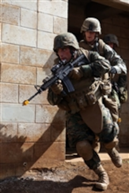 U.S. Marine Corps Sgt. Chance Walsch (left) and Lance Cpl. Russell Stine exit a building with their M-4 carbine rifles at Schofield Barracks, Hawaii, on Sept. 16, 2009.  Walsch is assigned to Bravo Company, 1st Battalion, 3rd Marine Regiment and Stine is assigned to Alpha Company, 1st Battalion, 9th Marine Regiment.  Both Marines are students participating in an infantry squad leader's course conducted by Advanced Infantry Training Battalion, School of Infantry - West, Detachment Hawaii.  