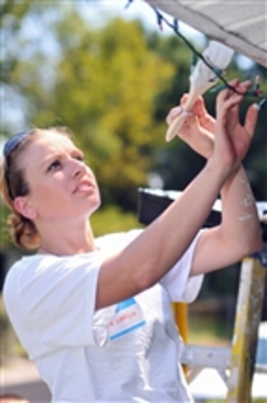 U.S. Navy Petty Officer Stephanie Simpson, assigned to Naval Nuclear Power Training Command, Naval Weapons Station Charleston, S.C., repaints the exterior trim of a home as part of the 2009 Day of Caring in Charleston, S.C., on Sept. 11, 2009.  More than 2,000 sailors throughout Charleston are volunteering in this community effort.  