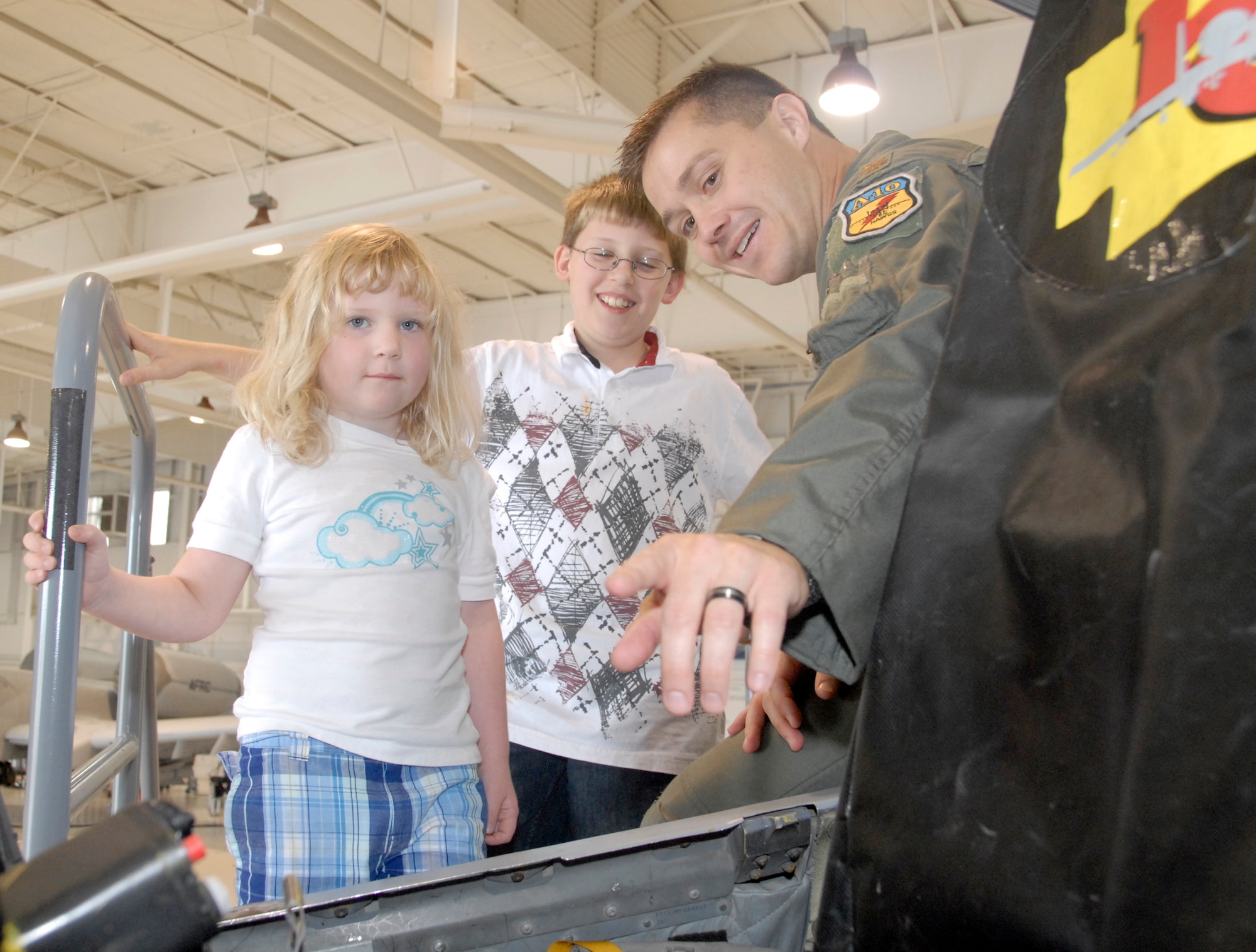 Maj. Todd Riddle, A-10 pilot from the 303rd Fighter Squadron, explains an A-10 Thunderbolt II cockpit to Mason, 10, and Samantha, 5, during a Yellow-Ribbon program event at the 442nd Fighter Wing at Whiteman Air Force Base, Mo., Sep. 26.  The Yellow-Ribbon program is designed to assist Air Force Reservists and their familly members deal with the stress of extended combat deployments.  Mason and Samantha are the children of a 442nd Security Forces Squadron Citizen Airman currently deployed for Operation Iraqi Freedom.  Currently, many of the wing's security forces members are deployed to provide air-base defense at deployed locations.  The 442nd Security Forces Squadron deploys more than any other unit in the wing, which has a proud tradition of deployments for the Global War Against Terror.  (U.S. Air Force photo/Maj. David Kurle) 